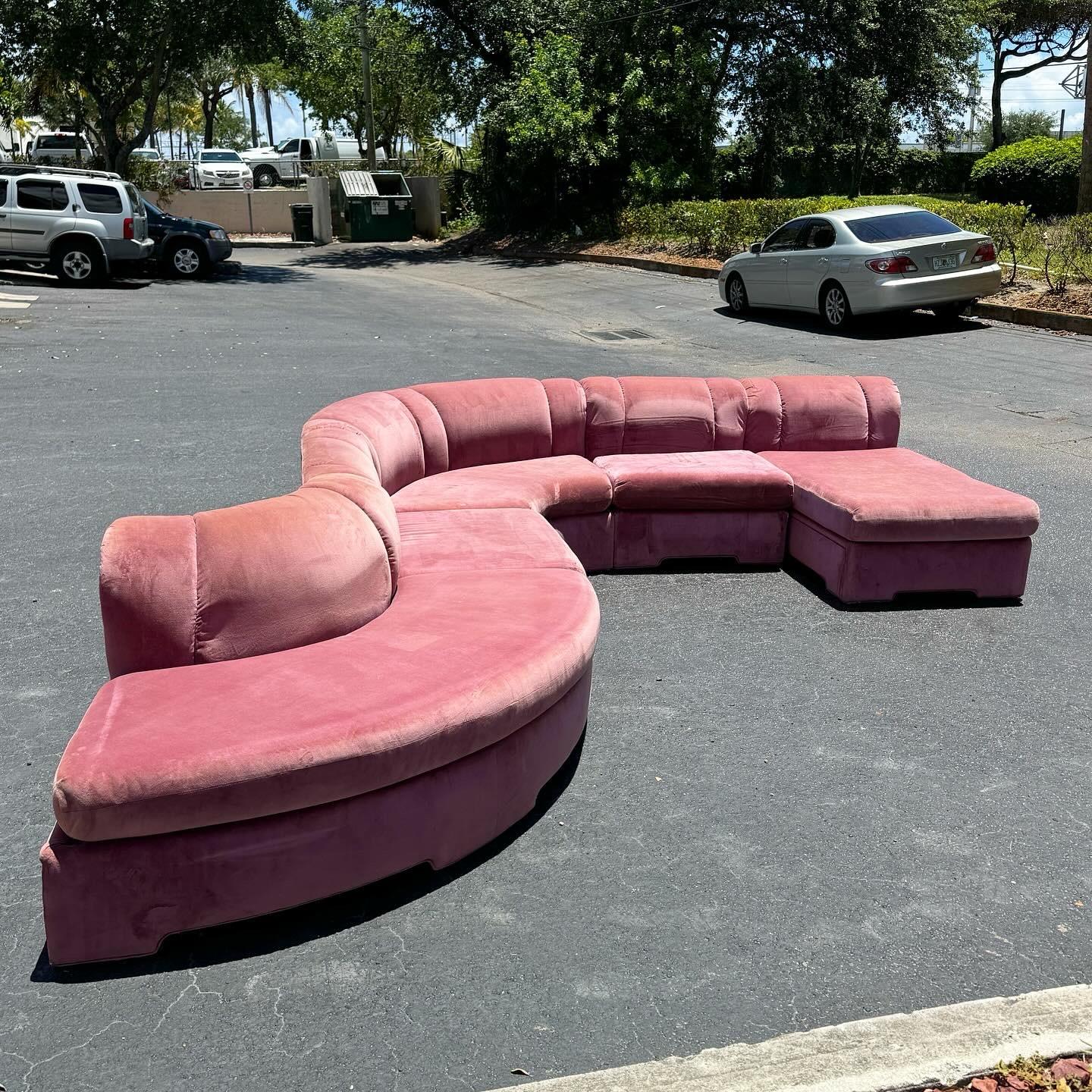 Revitalize your living area with the Postmodern Pink Modular Sofa Set by Carson’s, featuring two curved sections, a chaise, and two regular sections. The eye-catching pink upholstery adds a lively touch, while the modular design offers versatile