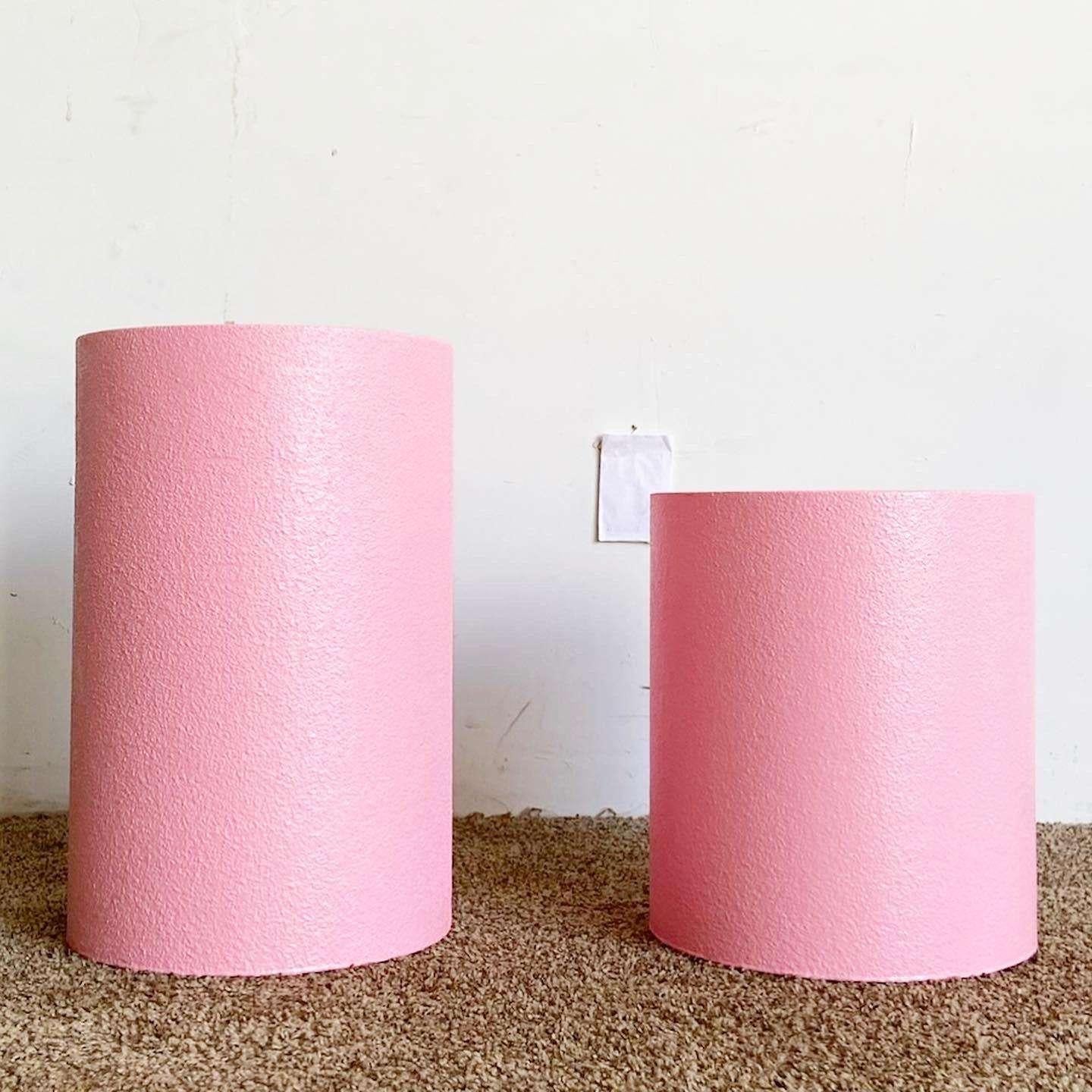 Amazing vintage pair of postmodern cylindrical pedestals. Each feature a bubble gum pink testified finish.

Small pedestal measures 15”H