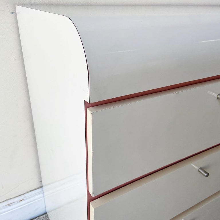 Amazing postmodern 1980s waterfall lowboy dresser. Features a white and pink lacquer laminate.
 