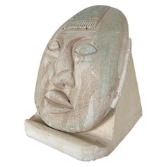 Escultura posmoderna de cara de escayola sobre peana