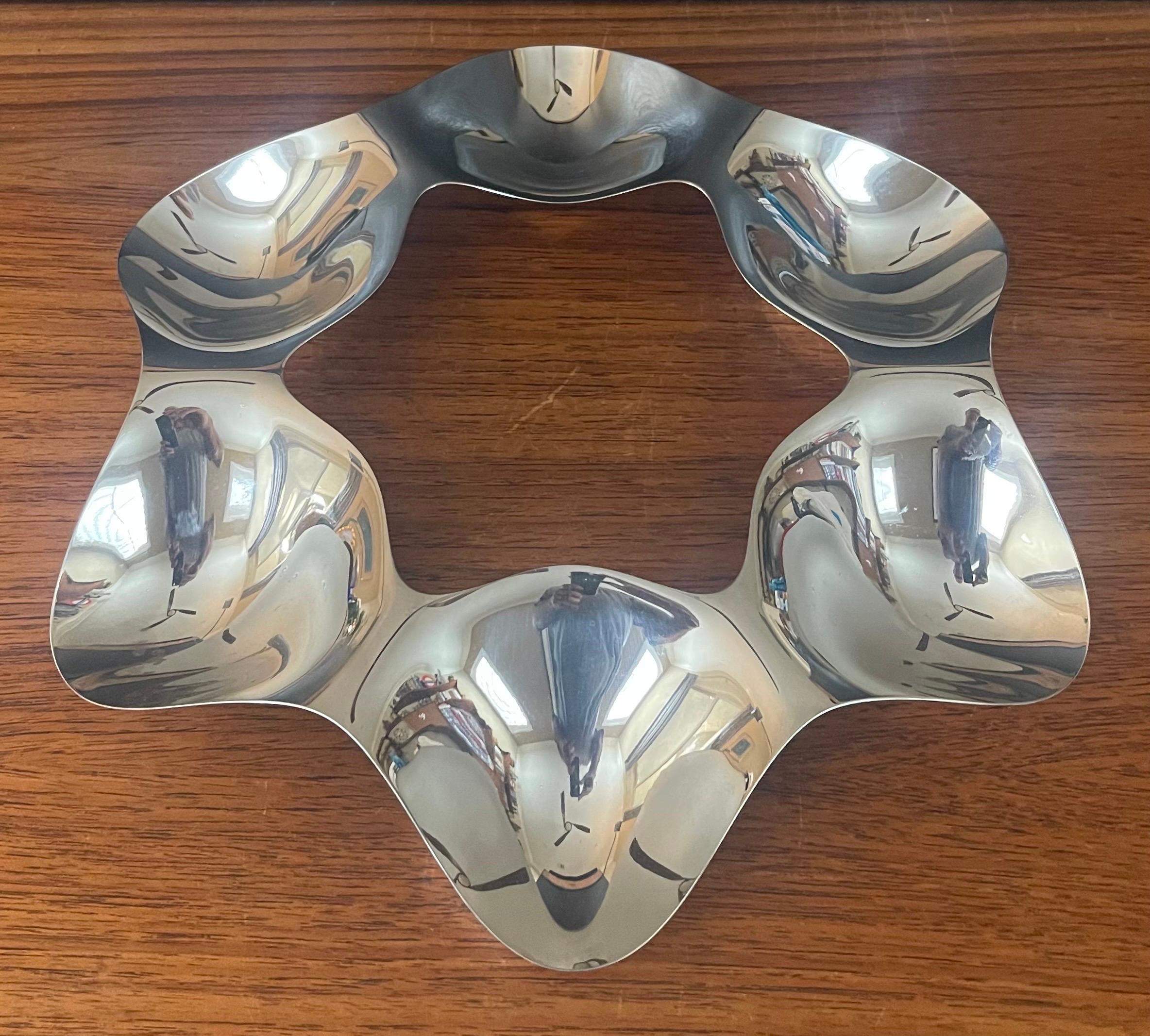 A very nice postmodern polished stainless steel hors d'oeuvre tray by Tom Kovacs for Alessi, circa 2000's. This is a very cool and functional piece that has six sections in a star shaped tray. The piece meaures 12.5