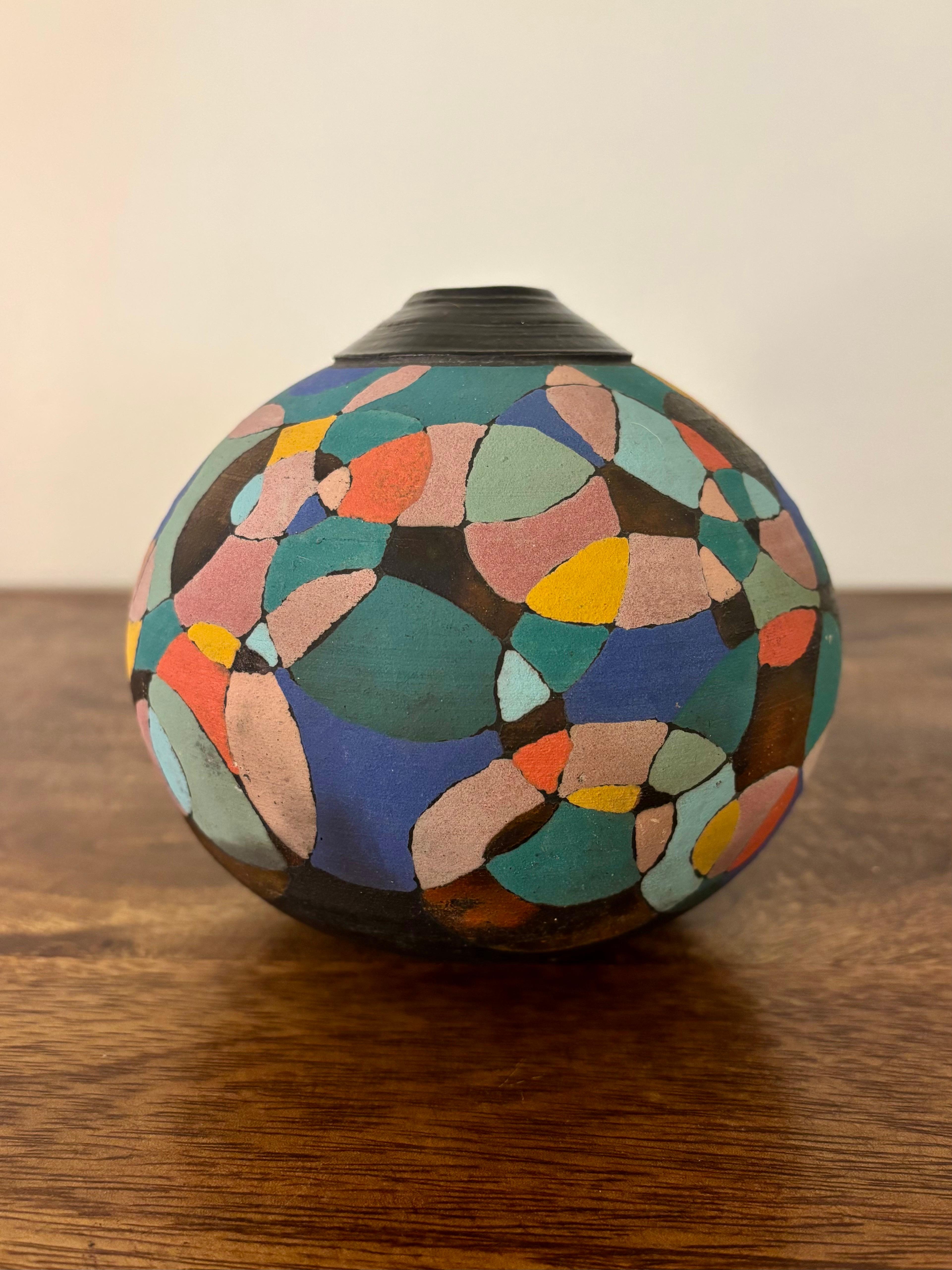 Un pezzo eccezionalmente unico di ceramica Raku. Ricoperto di cerchi eclissanti che sono stati per lo più rifiniti con colori opachi e brillanti. Alcuni cerchi mantengono la finitura originale Raku. 

Il marchio del produttore è impresso sul lato