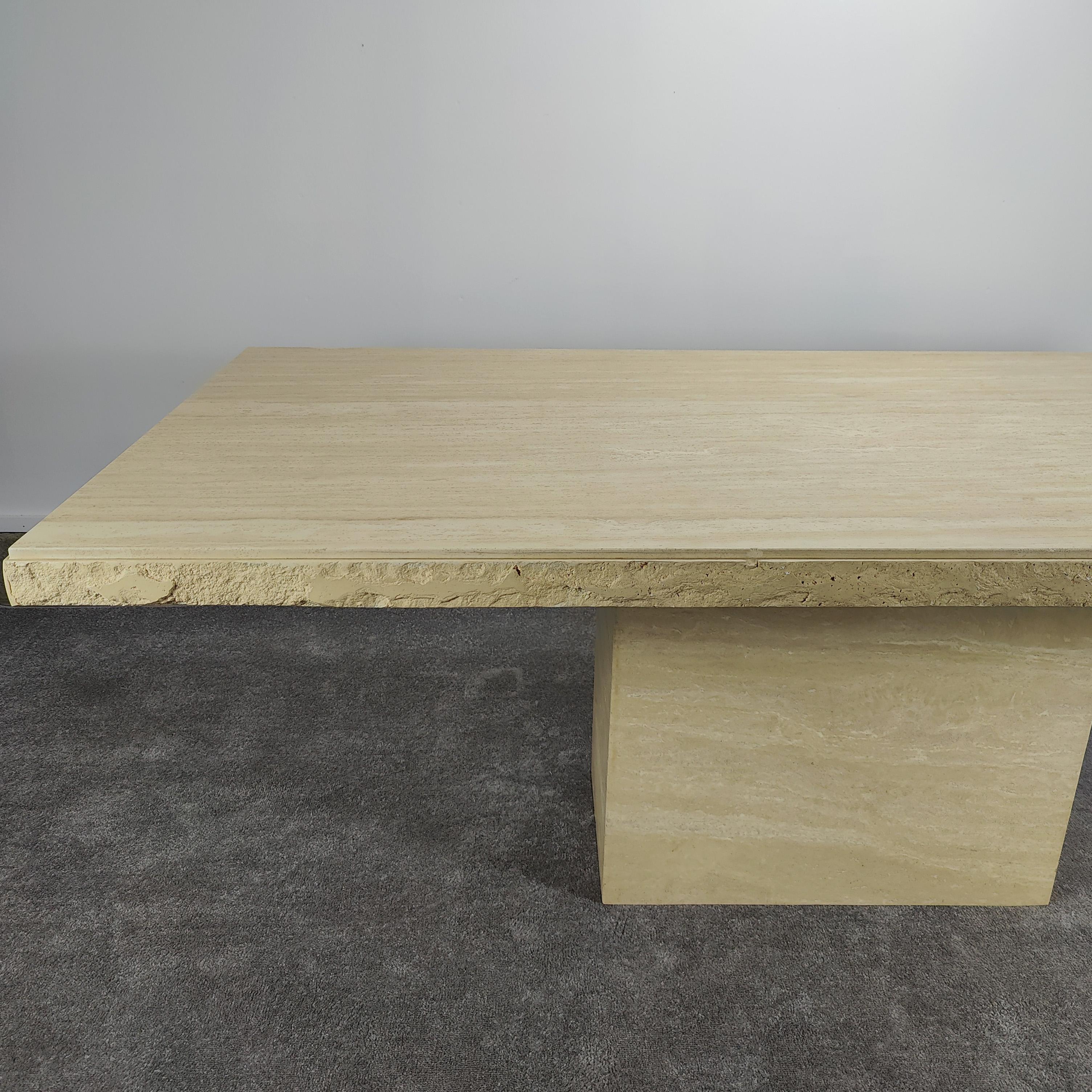 Now available, a monumental Italian travertine stone dining table, circa the 1980s. This piece showcases a rectangular pedestal base and a large thick rectangular tabletop. A beautiful 'live edge' and subtle veins add to the details of this gorgeous