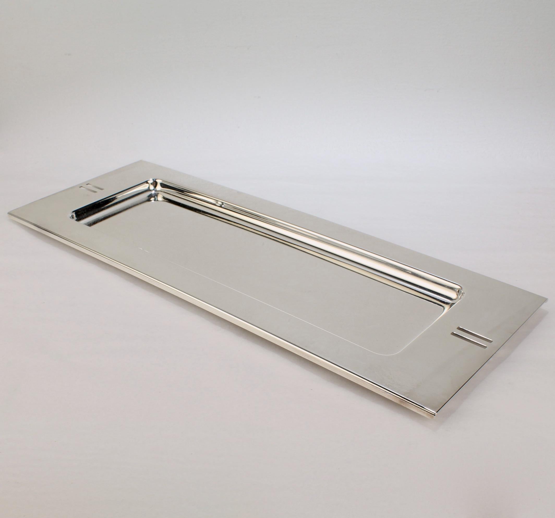 A postmodern silver-plated rectangular tray.

Designed by Richard Meier for Swid Powell.

Model no. 3416.

Together with its original box.

Swid Powell was the highly acclaimed New York City based tableware company founded by Nan Swid and Addie
