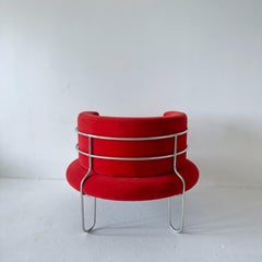 Postmodern red circular lounge chair caged in tubular steel
