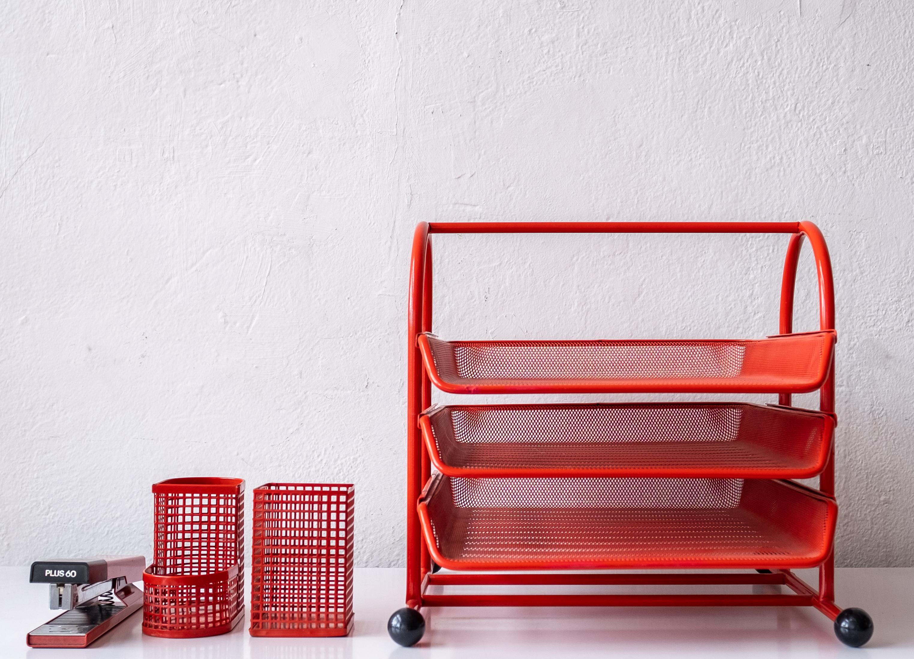 A wonderful Post-Modern red enamel perforated metal desk set. It includes a letter tray with sliding trays, stapler, pencil cup and storage container. Japan.