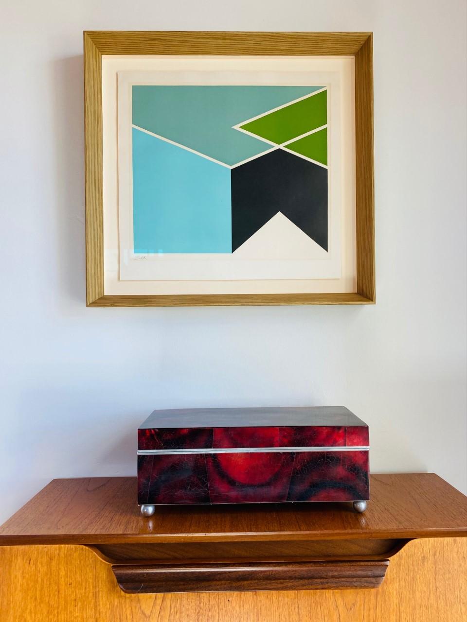 Diese wunderschöne Box von Maitland Smith strahlt Stil und Glamour aus. Dieses Design aus den späten 1980er Jahren ist glamourös und funktionell. Die postmodernen Linien in einer fast zylindrischen Sockelstruktur sind mit einer wunderschönen, rot
