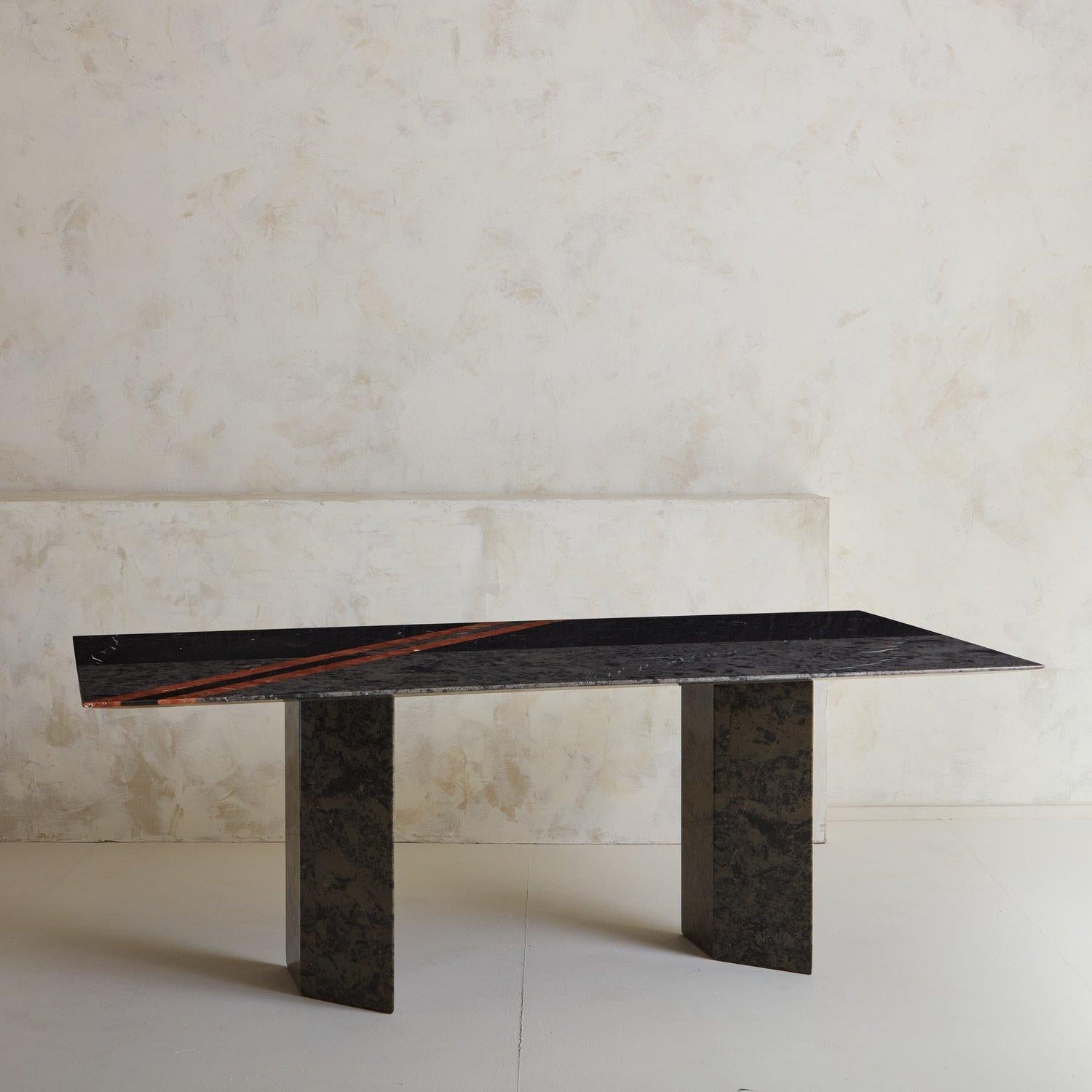 A 1980s Postmodern Roche-Bobois marble dining table constructed with Grigio Marquina and Rosso Albania marble with a beautiful linear design. The tabletop has an elegant sharknose beveled edge, offering the support of a thicker stone while