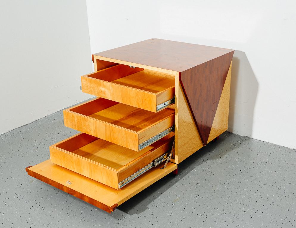 Postmodern cabinet or bar on casters. Burl maple and mahogany veneer construction with three drawers.