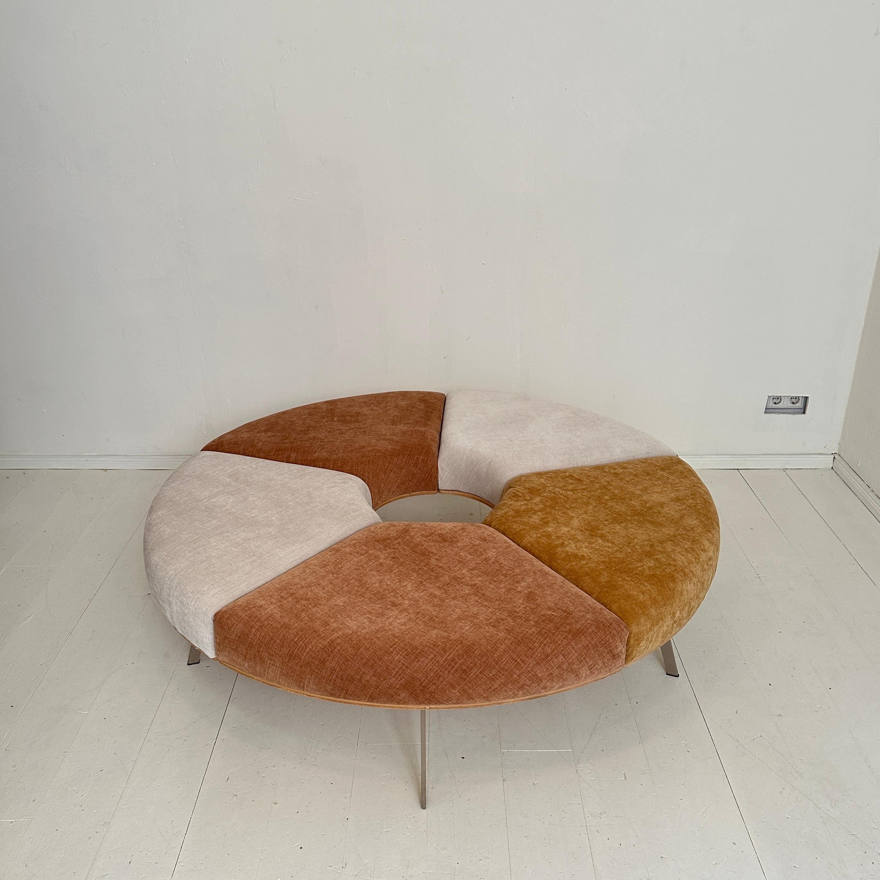 Il divano rotondo postmoderno Rondell in lussuoso tessuto di velluto, progettato nei vivaci anni '80, è un capolavoro iconico del design moderno. La sua forma generosa e circolare abbraccia la spontaneità e il comfort, invitando a incontri casuali e