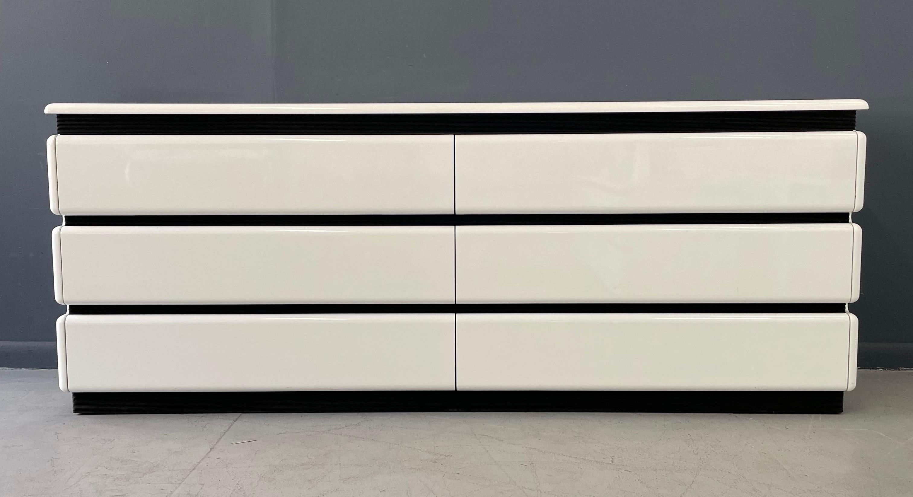 High gloss white lacquer six drawer dresser with Rougier's iconic ribbed black rubber accents; this dresser represents post modern period perfectly. Rougier furniture is of the highest quality with excellent finishes and substantial