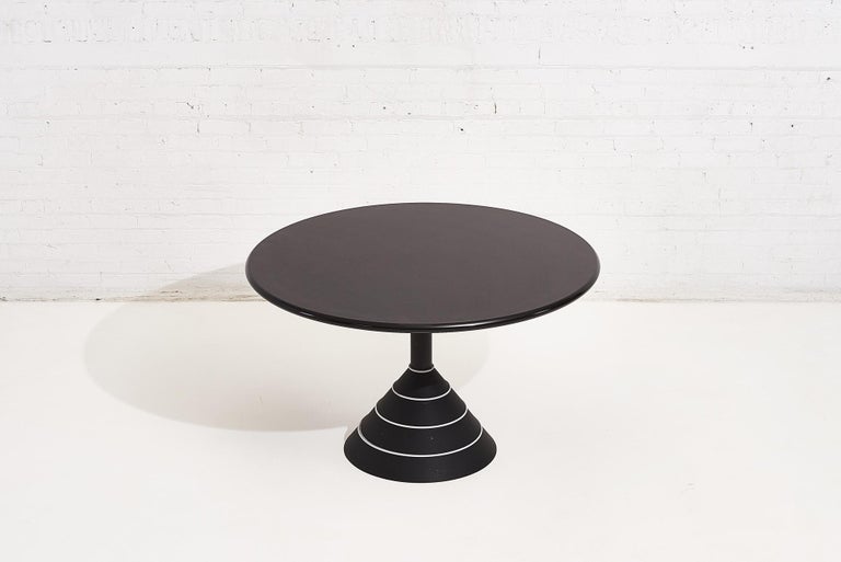 Postmodern round dining table. Black pyramid shaped base has white rings going around it. Black and white Memphis dining table, circa 1980s.