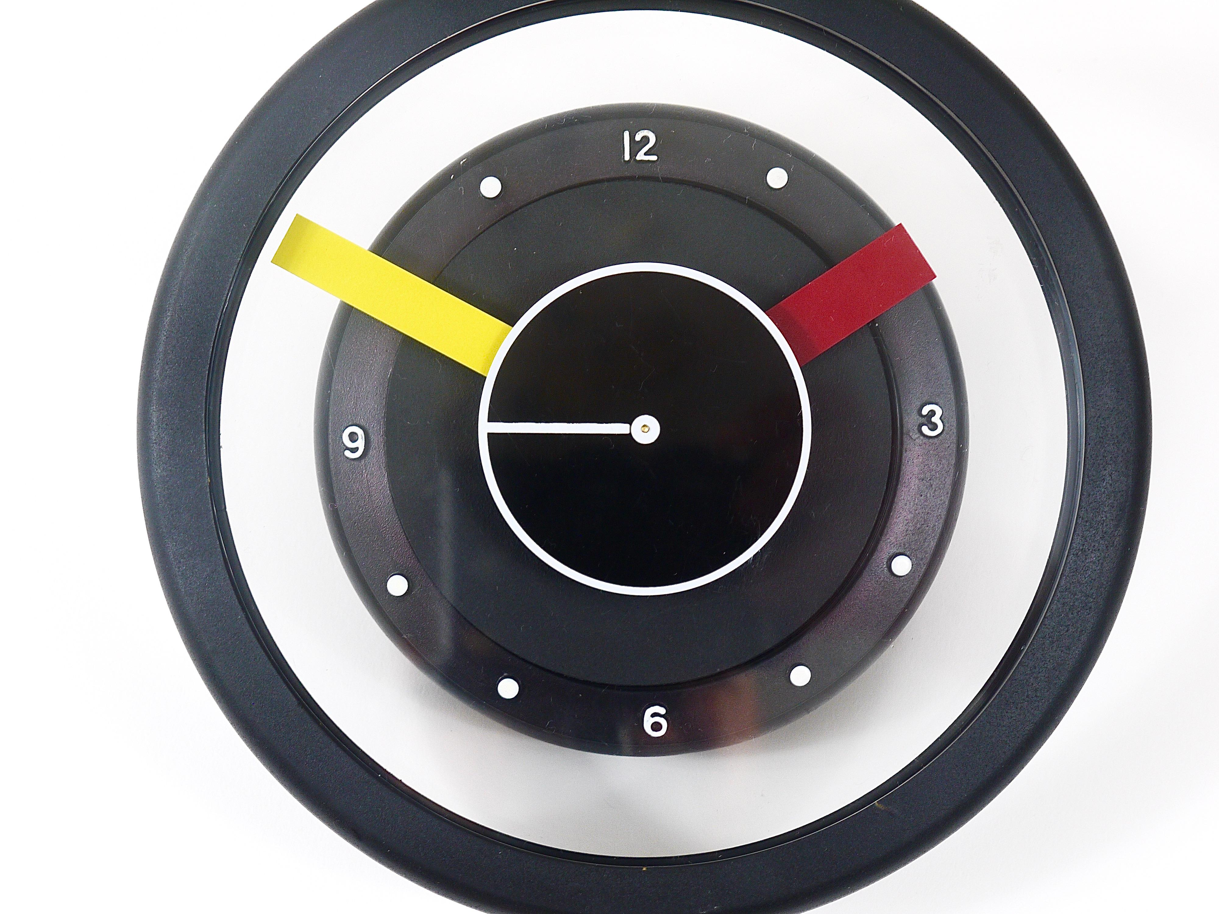 An eye-catching post-modern Pop-Art Italian desk or table clock from the early 1990s. Outstanding design, the housing is made of black rubber, it has a clear see-trough clocks face, a red and a yellow hand and the second hand is a rotating black and