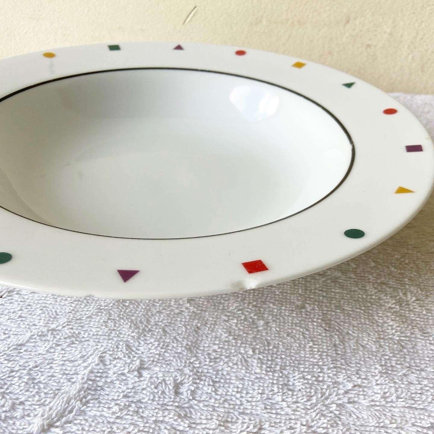 Amazing vintage postmodern set of 7 dinner bowls by Sakasi. Each feature red, yellow, green and purple triangles, squares and circles bordering the edges.
