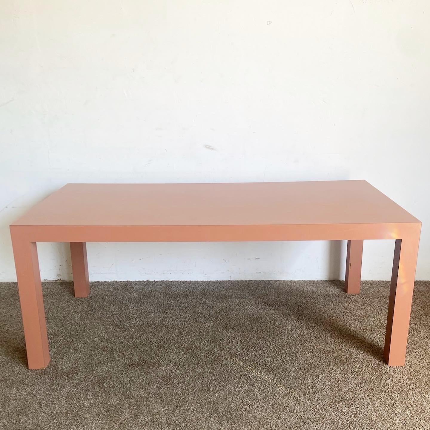 Elevate your dining experience with this Postmodern Salmon Matte Laminate Parsons Dining Table. Its clean lines and bold salmon color make it a unique yet versatile piece for any modern or postmodern setting.
Some wear to the legs and marks to the