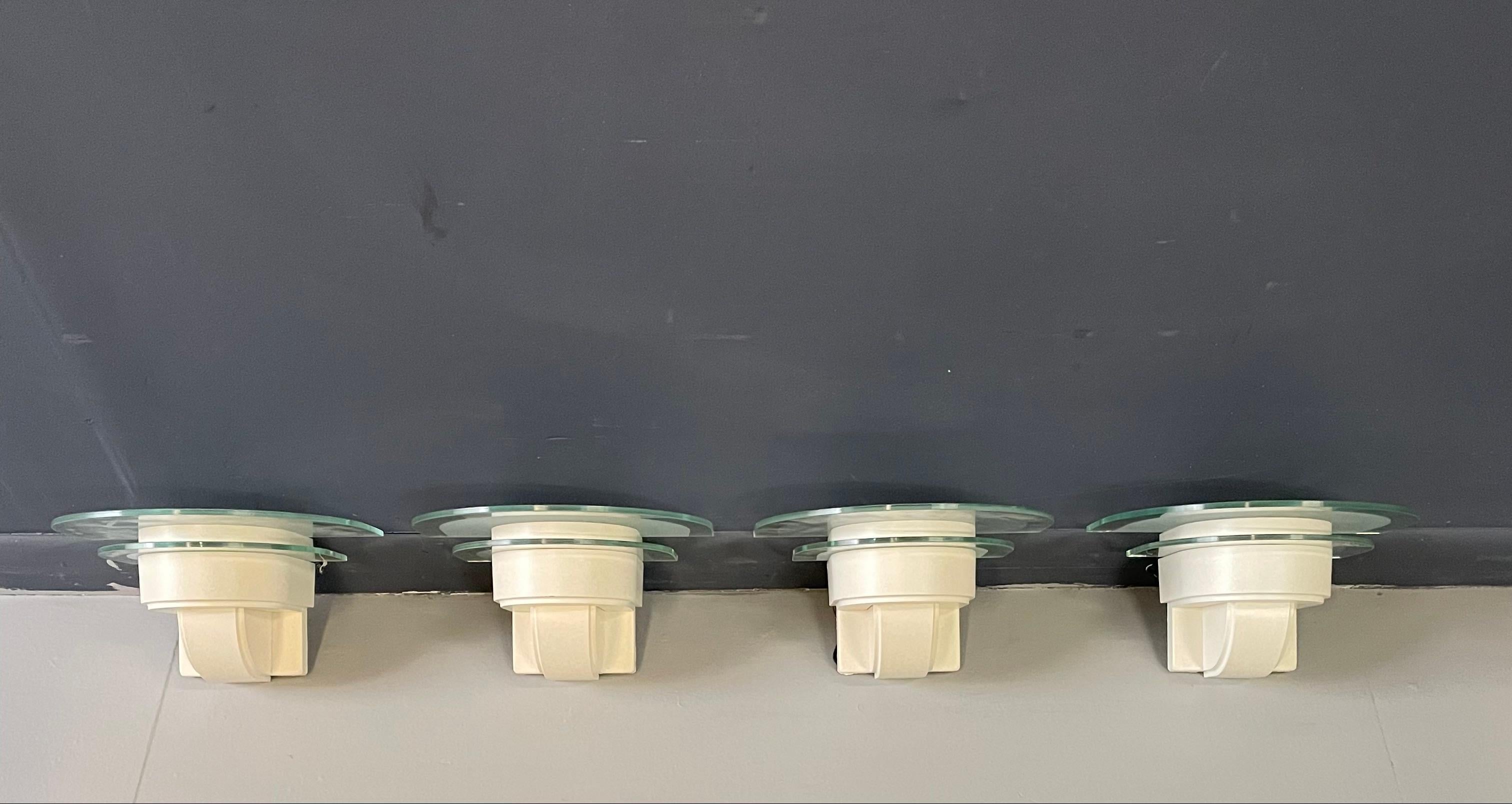 Quintessential 1980s style scones reminiscent of the work of architect Richard Meier. Each sconce has two glass semi-circle glass shades the larger top one is part frosted.

There are four sconces total available in pairs.