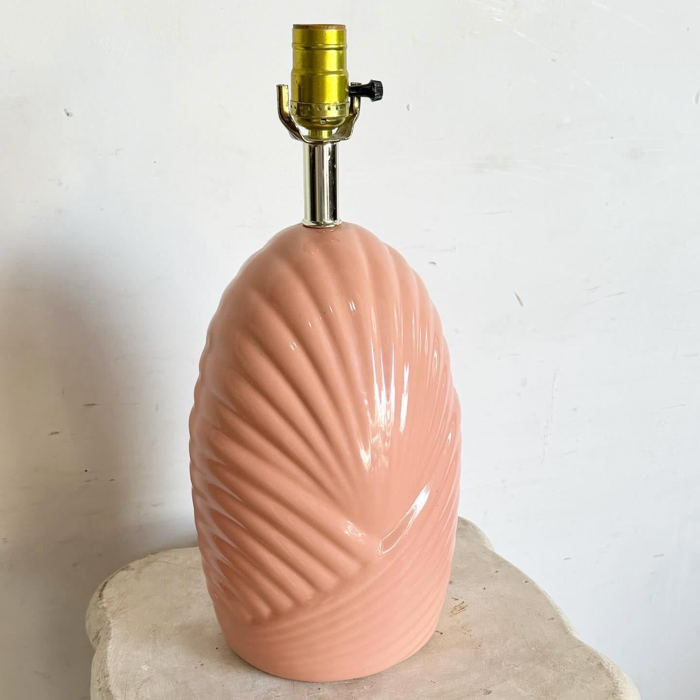 The Postmodern Sculpted Coral Pink Scalloped Table Lamp is a captivating addition to any contemporary space. Featuring a unique postmodern design with playful scalloped edges, its vibrant coral pink hue adds warmth and style. Perfect for living