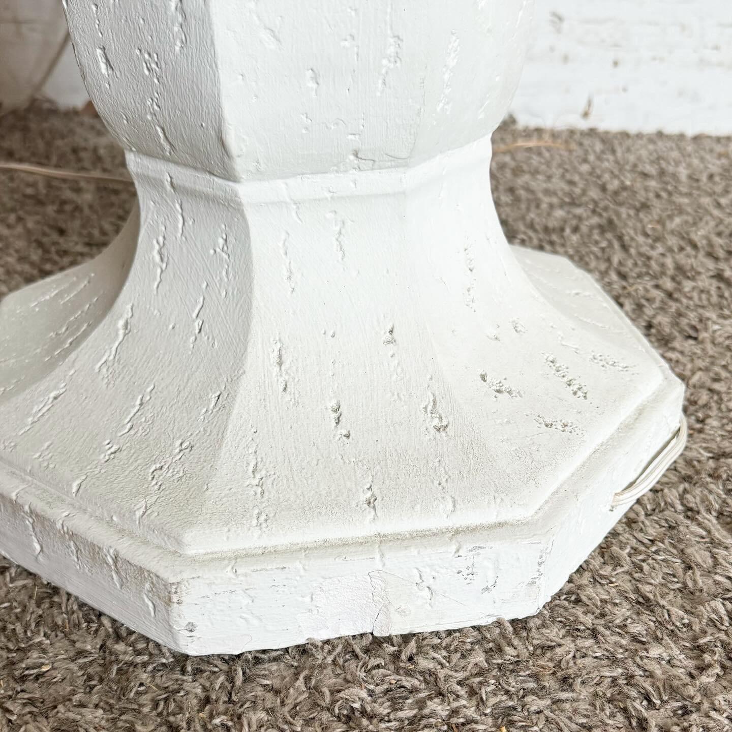Tauchen Sie ein in die minimalistische Eleganz dieser postmodernen, skulpturalen Stehleuchte aus weißem Gips. Der Sockel der Leuchte ist kunstvoll aus Gips gefertigt und weist ein einzigartiges skulpturales Design auf, das geometrische Formen mit