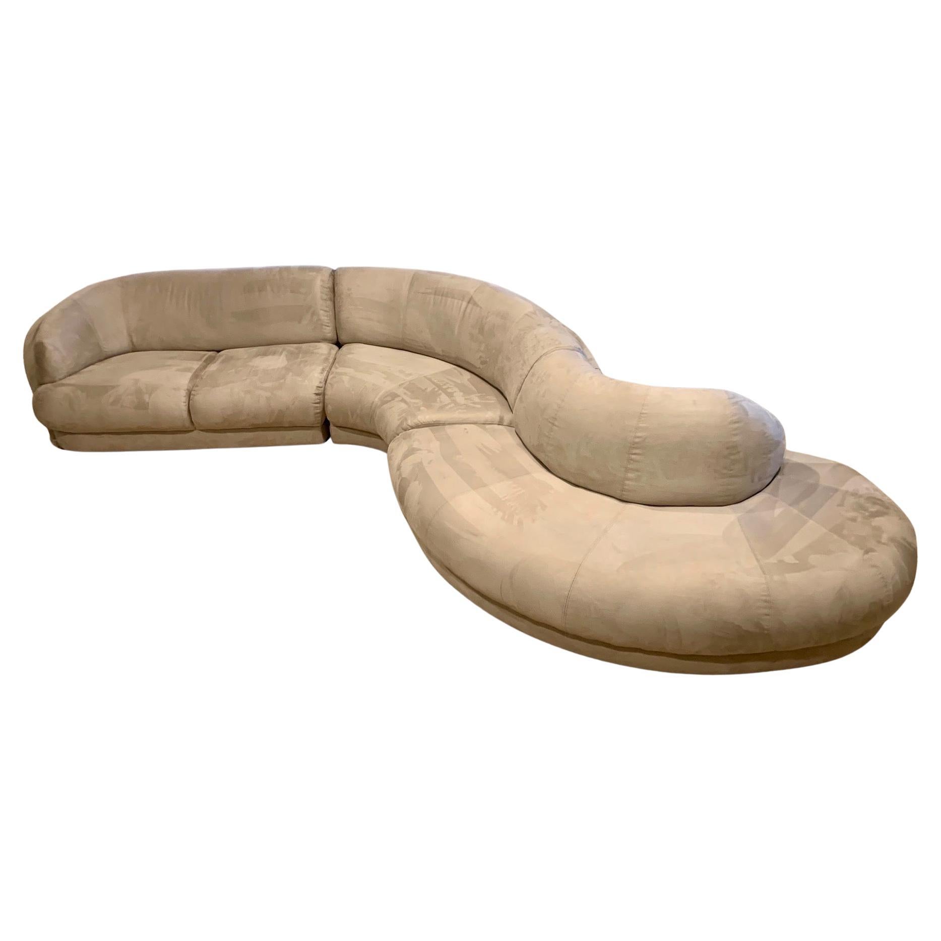 Monumental canapé sectionnel en serpentine dans le style de Vladimir Kagan et Milo Baughman. Ce canapé modulaire incurvé unique se compose de trois sections qui s'emboîtent les unes dans les autres et qui sont recouvertes d'un tissu Ultrasuede de