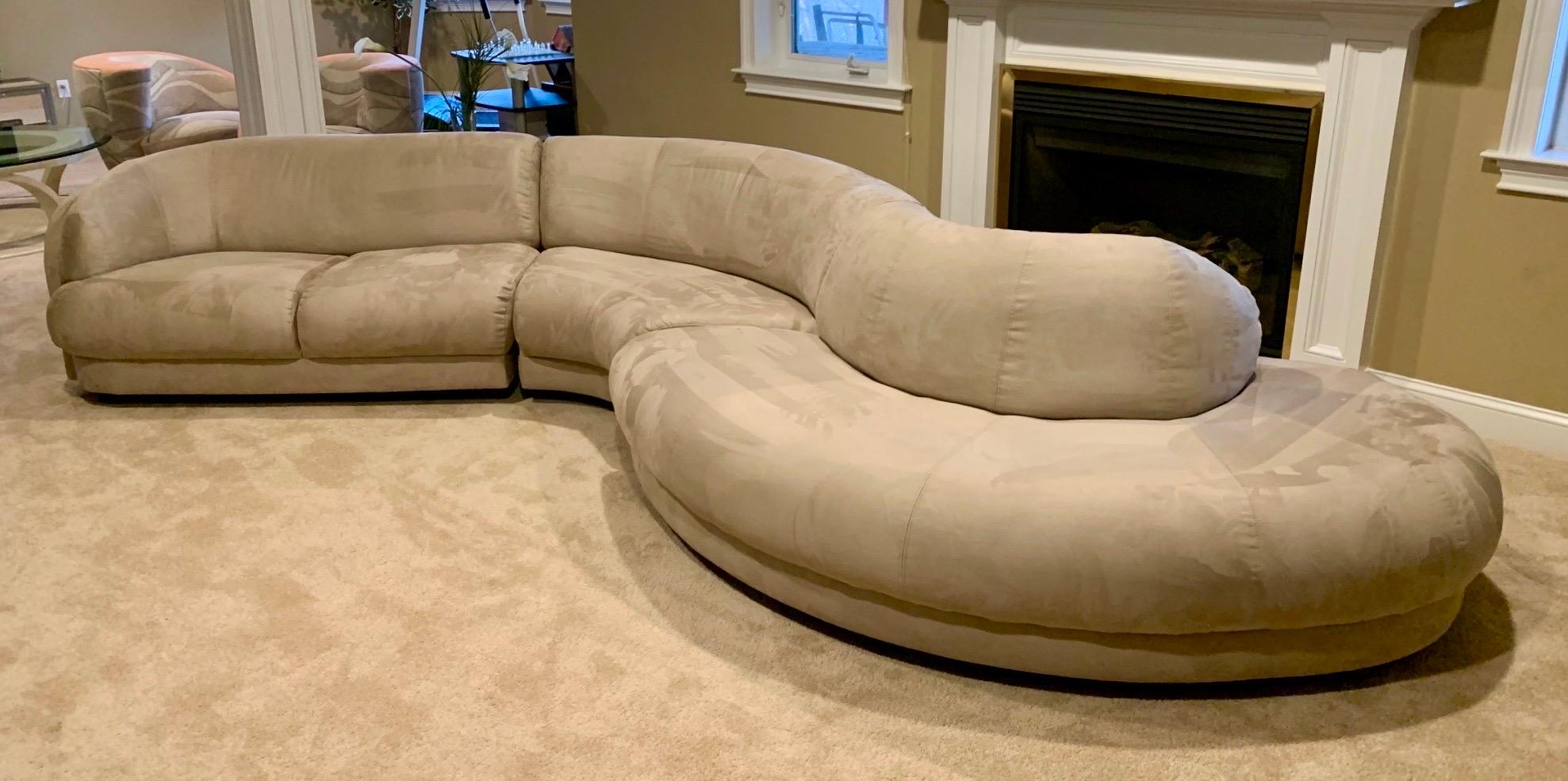 Monumental serpentine snake sectional sofa in the style of Vladimir Kagan and Milo Baughman. This unique modular curved sofa consists of three interlocking sections which have been professionally reupholstered in a neutral taupe tone Ultrasuede by