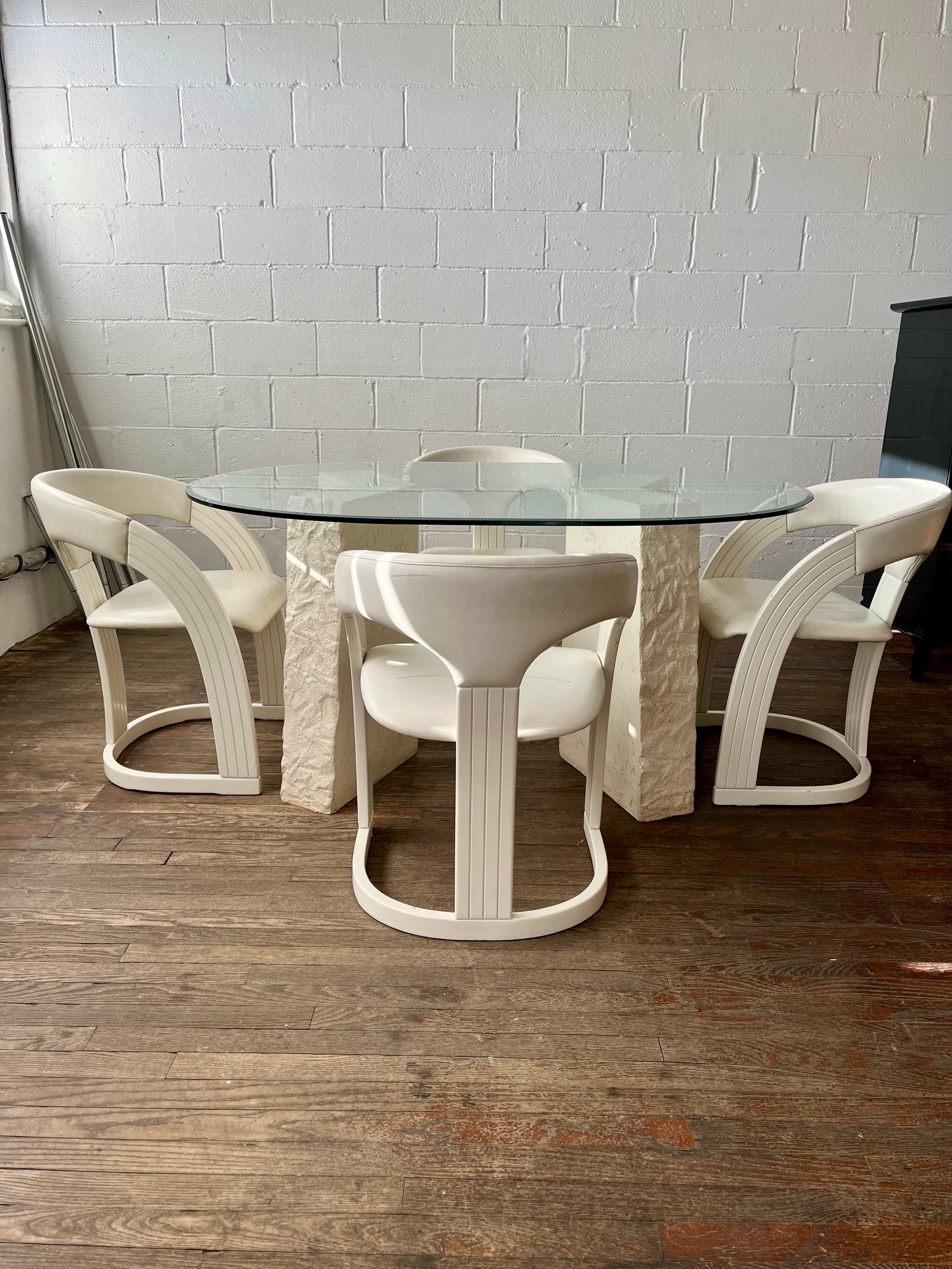 Fantastique table de salle à manger post-moderne et 4 chaises de salle à manger en laque et cuir fabriquées en Italie. 2 pieds géométriques effilés en forme de V. Plateau en verre épais biseauté. Les chaises ont un design légèrement incliné avec une