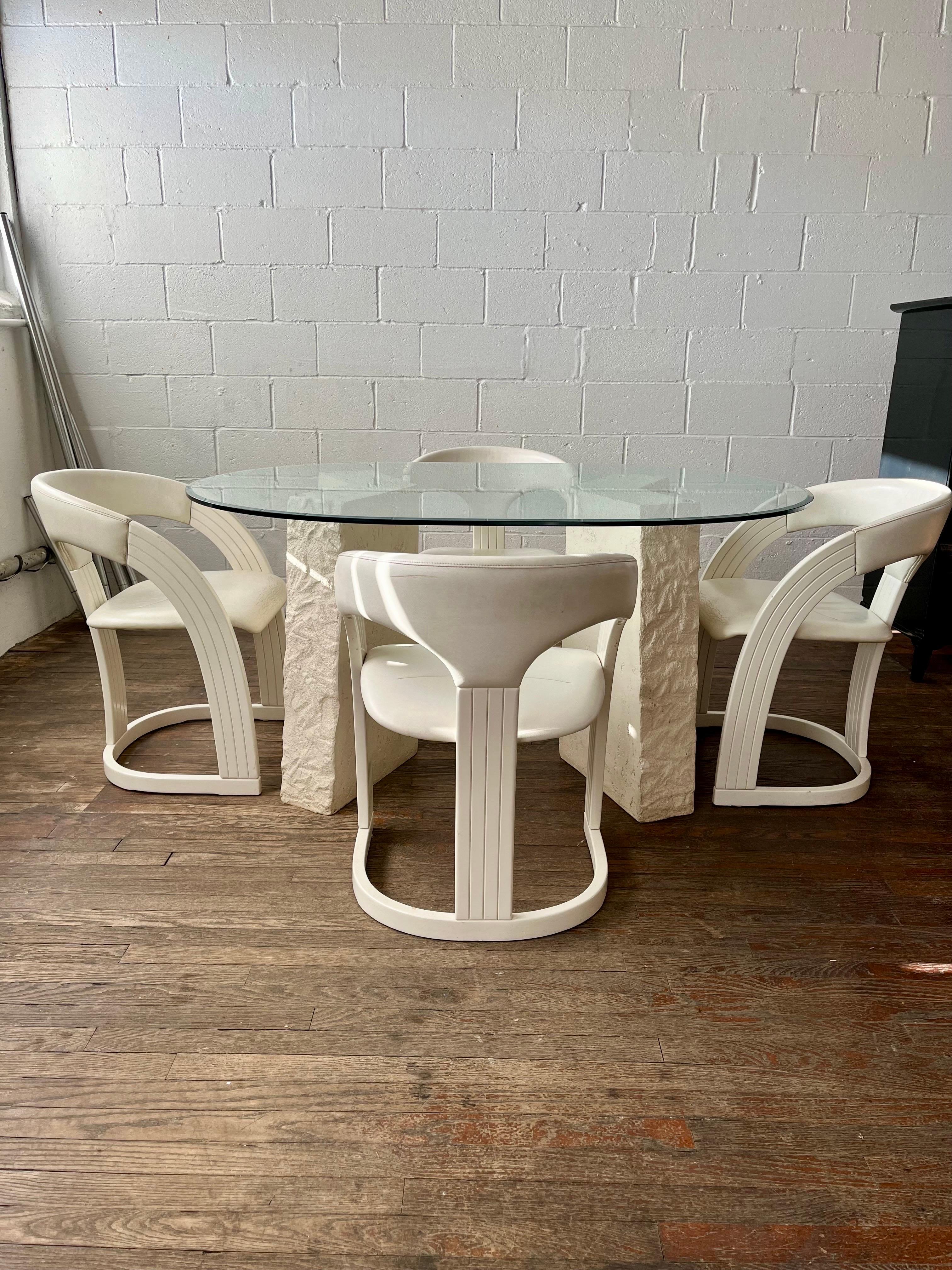 Fantastic post-modern dining table and 4 lacquer and leather dining chairs made in Italy. 2 tapered geometric V shaped base legs. Thick beveled glass top. Chairs have gentle sloping design with leather seat and back. Labeled made in Italy. Has a