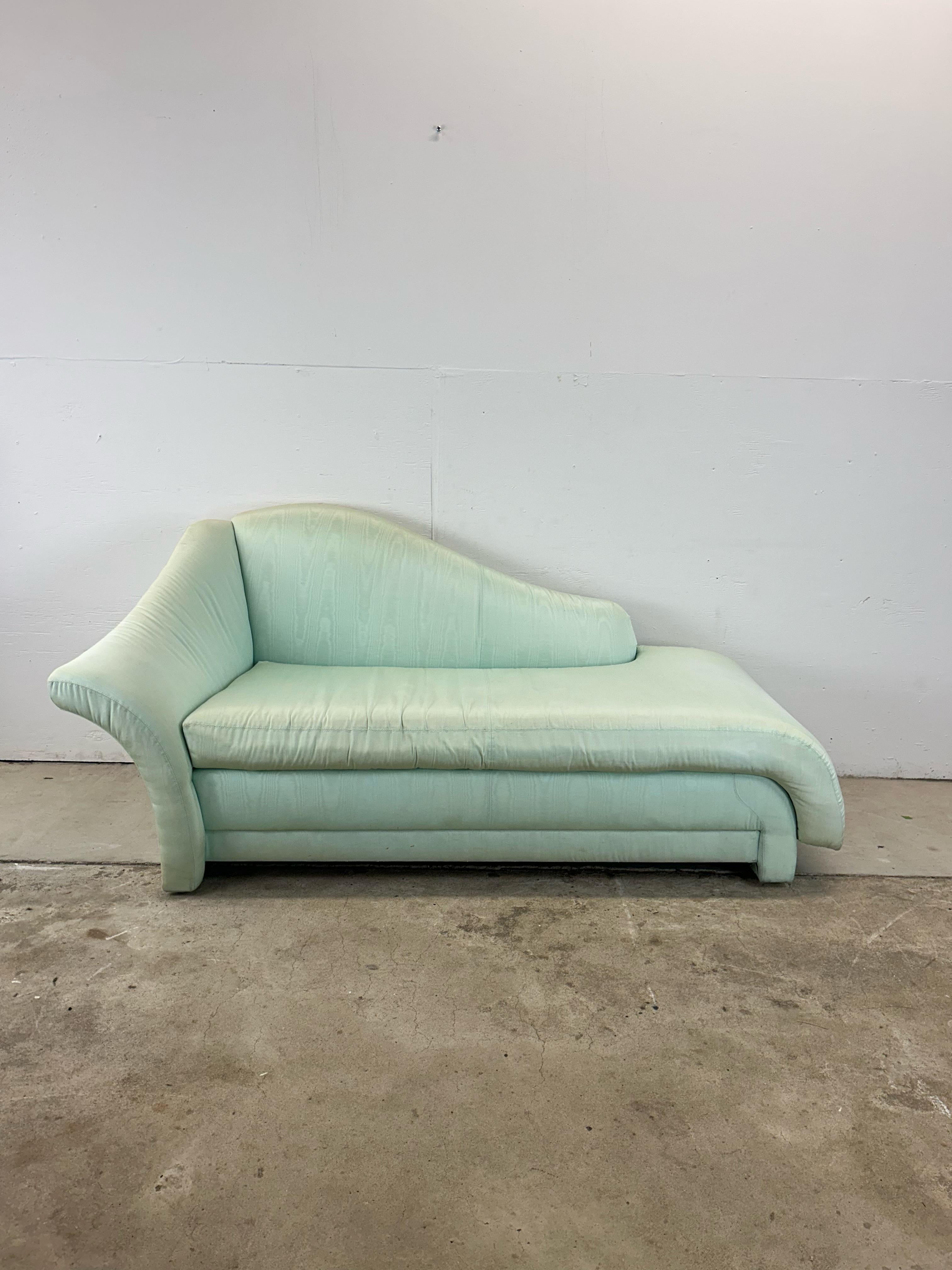 Esta chaise lounge de estilo posmoderno presenta un tapizado vintage en verde marfil, medio respaldo y reposabrazos únicos, base baja esculpida con patas tapizadas. u2028u2028Consulta nuestros otros listados postmodernos.

u2028Dimensiones: 72w 33d