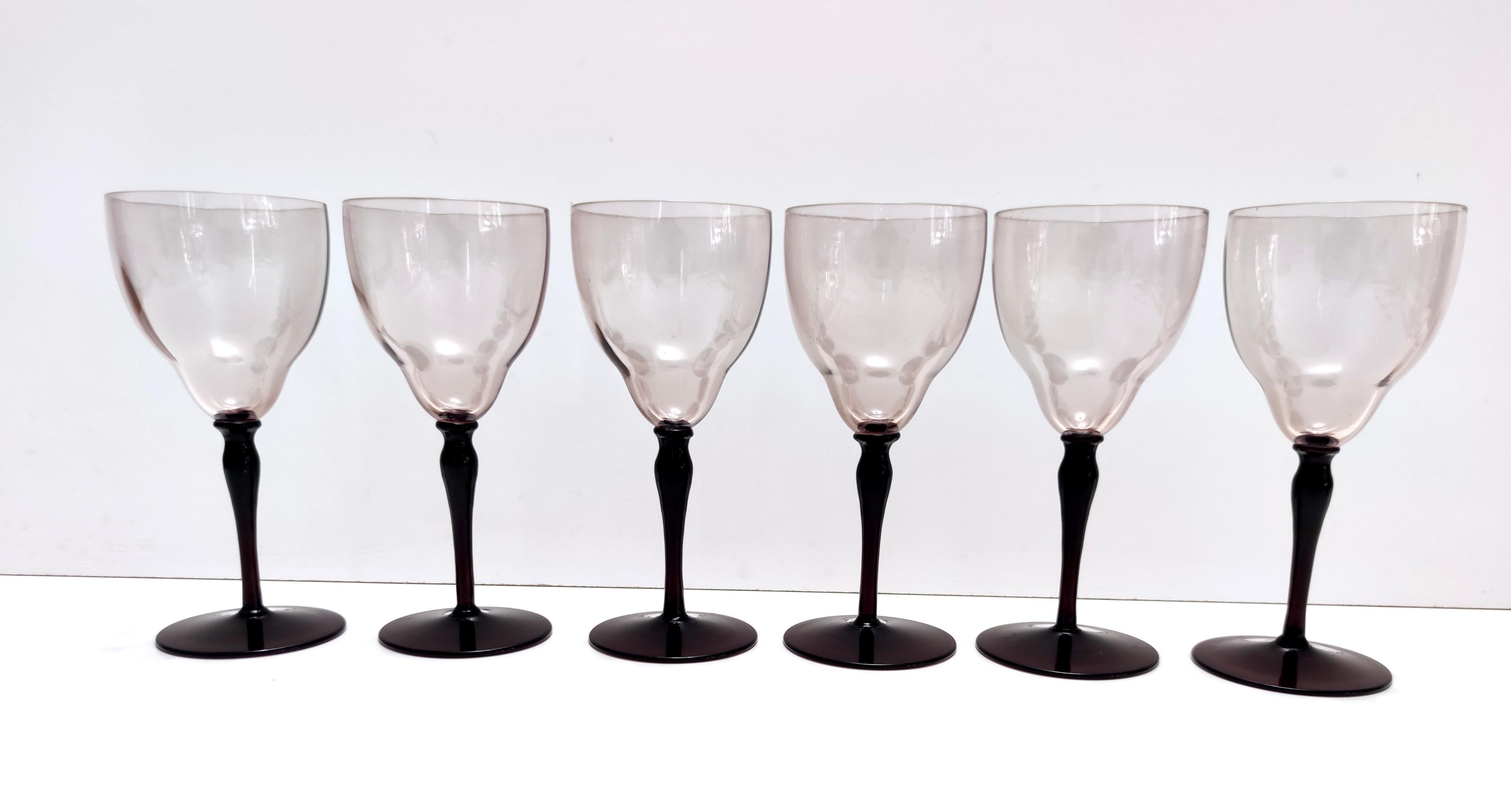 Made in Italy by Vittorio Zecchin, 1970s.
These six wine glasses are made in slight ribbed Murano glass. 
They are vintage, therefore they might show slight traces of use, but they can be considered as in perfect original condition and ready to