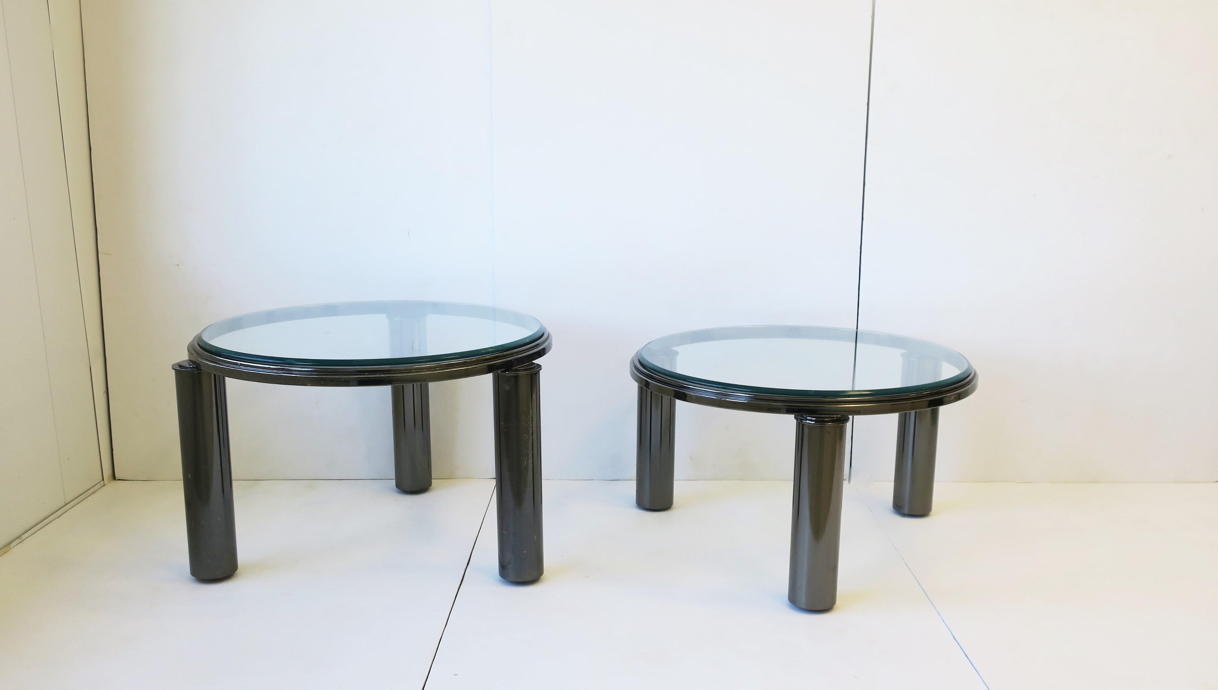 A set of two (2) designer 1990s Post-Modern 'smoked' gray-charcoal chrome round bi-level cocktail/coffee tables with cylindrical legs and beveled clear glass tops. Designed by the Design Institute of America (DIA), 1995. Smoked chrome has a dark
