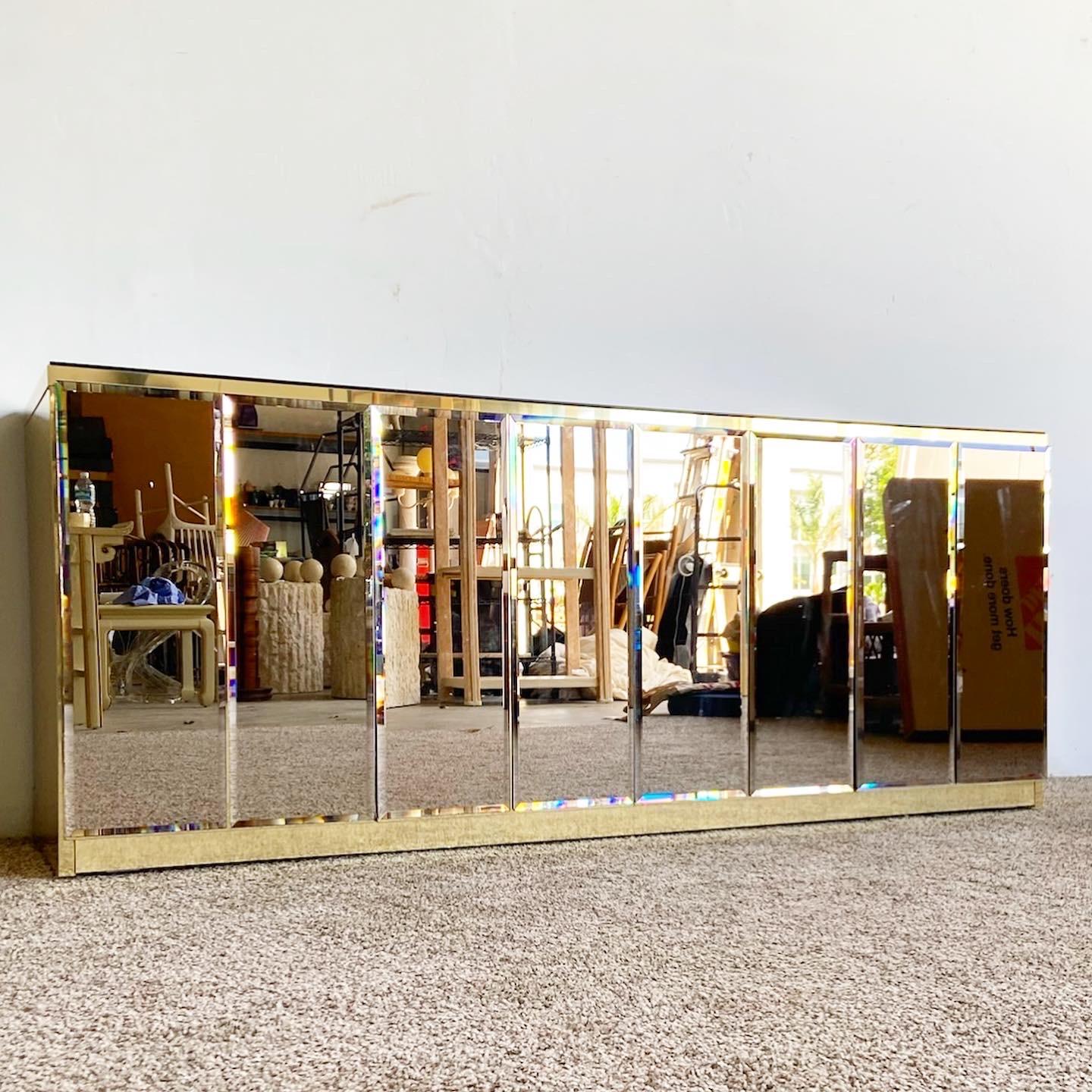 Phenomenal vintage postmodern credenza. This classic features a smoked mirror top and cabinet doors over a gold metal laminate. 4 doors open to reveal ample storage area.