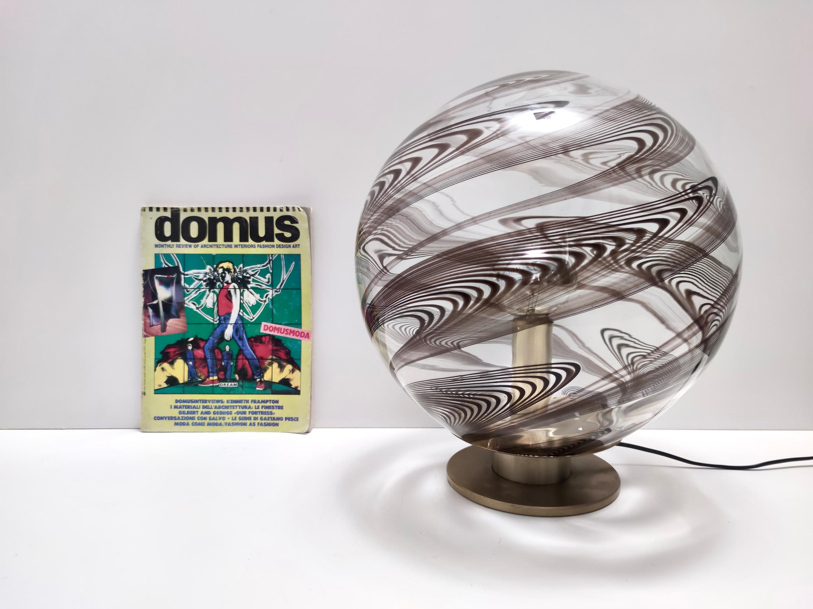 Made in Italy, anni '70-'80. 
Realizzato in ottone e vetro di Murano, presenta canne trasparenti e viola/marroni.
Questa lampada da tavolo è un pezzo d'epoca, quindi potrebbe presentare lievi tracce d'uso, ma può essere considerata in perfette