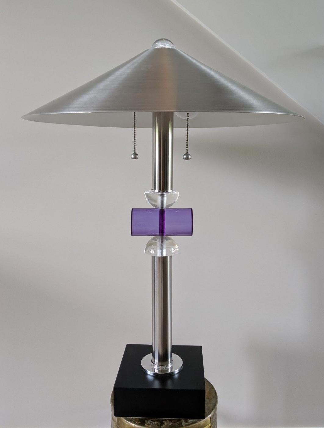 Fabulous Postmodern table or desk lamp with spun aluminum shade, chrome stem on black square base. Centre of stem is adorned with clear and purple acrylic elements and acrylic finial. Two bulb heads with pull chains.