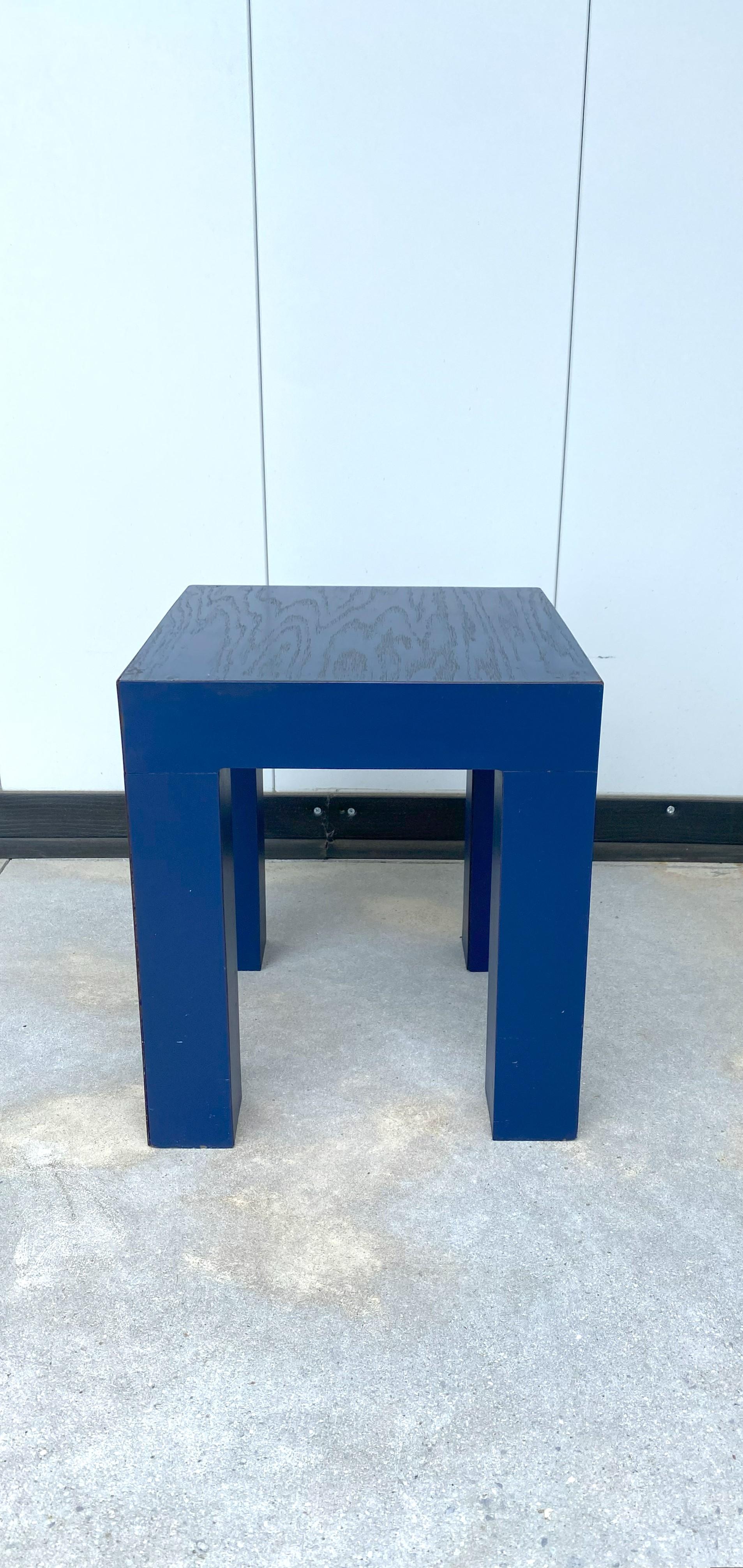 A cool, chic, small royal blue side/end/drinks table, Postmodern period, Memphis style, after designer Marco Zanini, circa late-20th century, 1980s. A monochromatic table in wood and blue laminate veneer. Table's top is raw wood with a royal blue