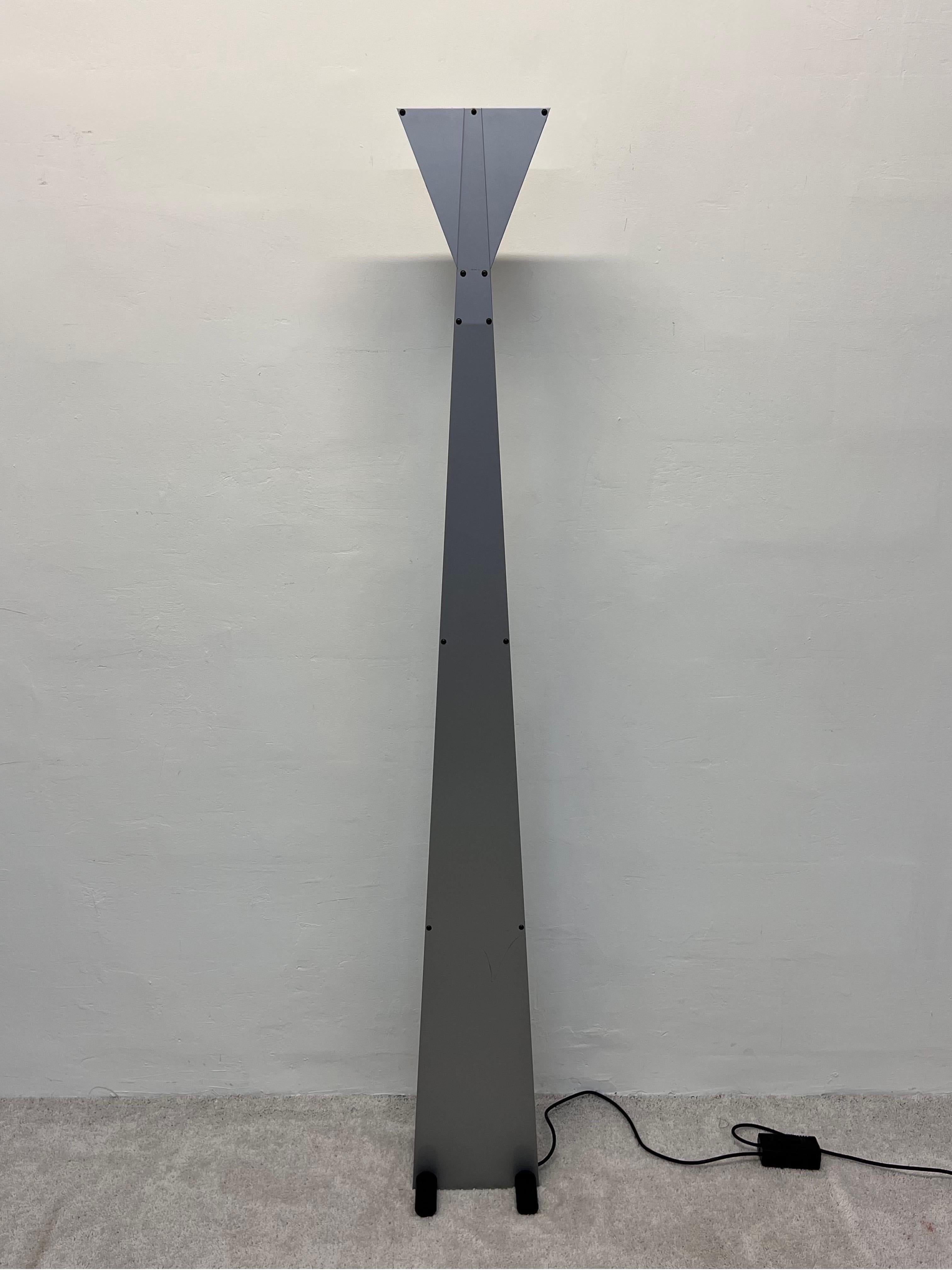 Lampadaire torchère postmoderne des années 1980 avec base en acier noir, support en acier gris et diffuseurs latéraux en verre bleu. La commande au pied en ligne permet de varier l'intensité de l'ampoule halogène.