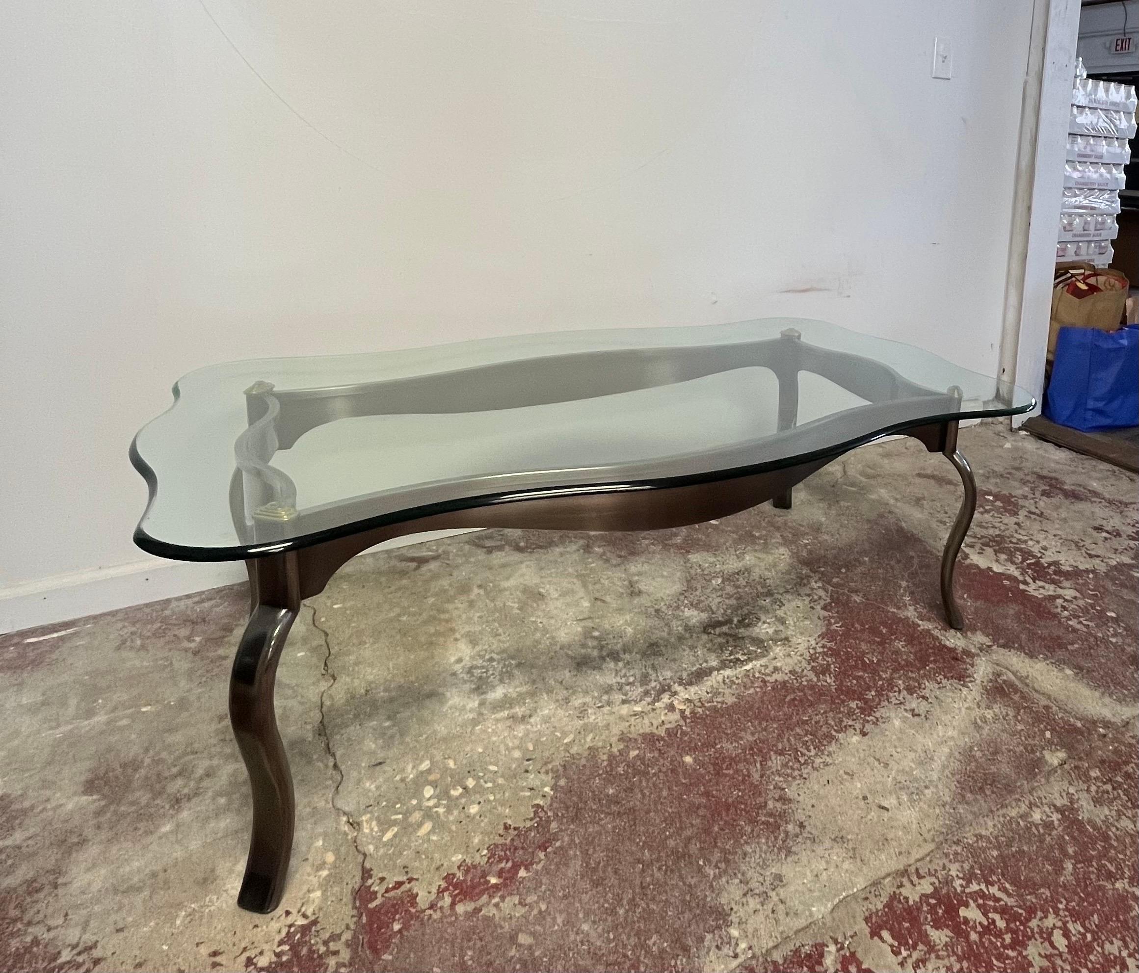 Wonderful post modern glass top coffee table. Smokey polished steel base with brass accent. Nice wavy lines in both base and glass top. 
Curbside to NYC/Philly $350