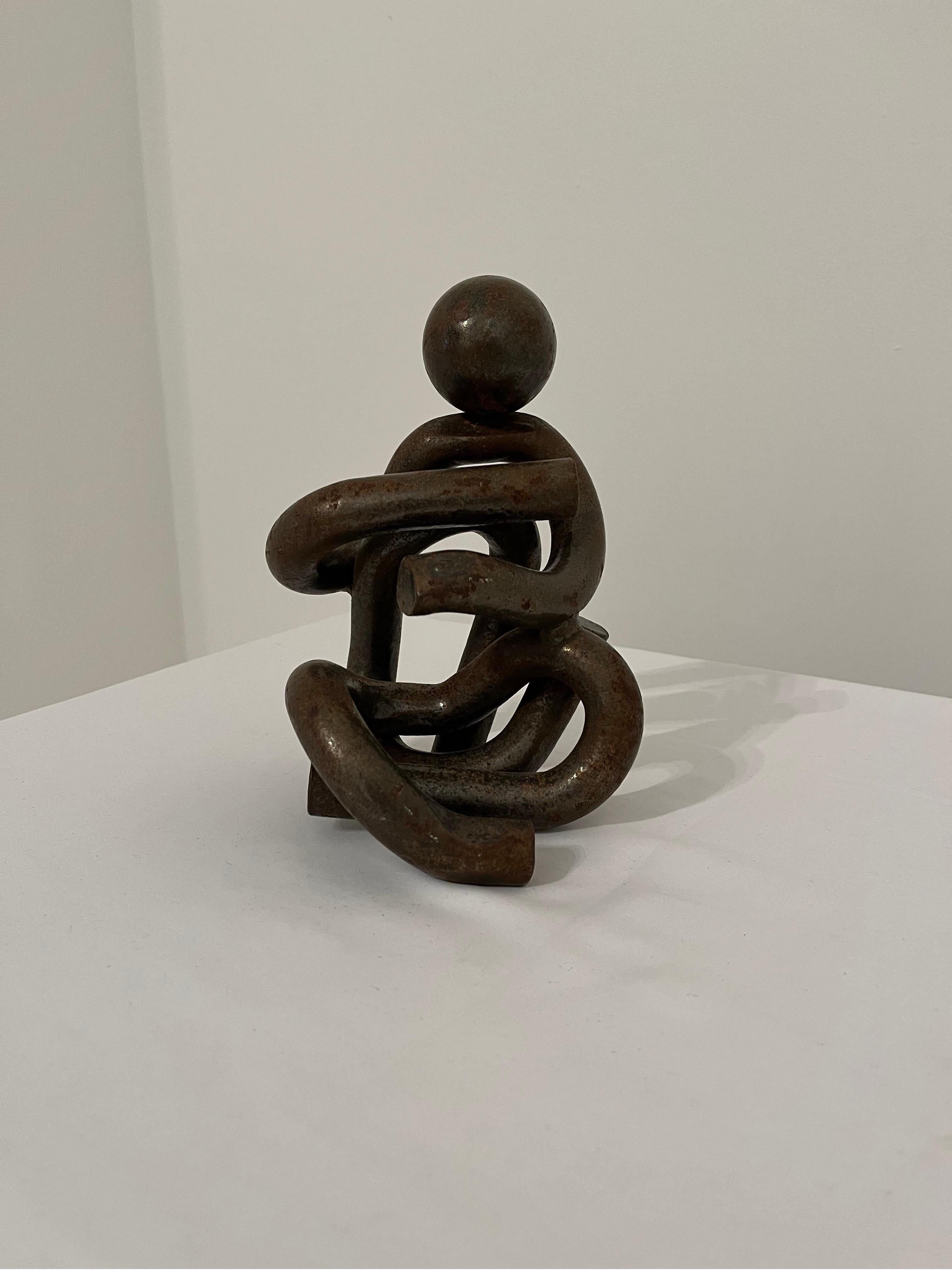 Sculptural lacquered steel seated figure. Condition as shown with heavy wear. Looks great as a shelf piece, bookend or doorstop. Great style perfect for the post-modern home. 
