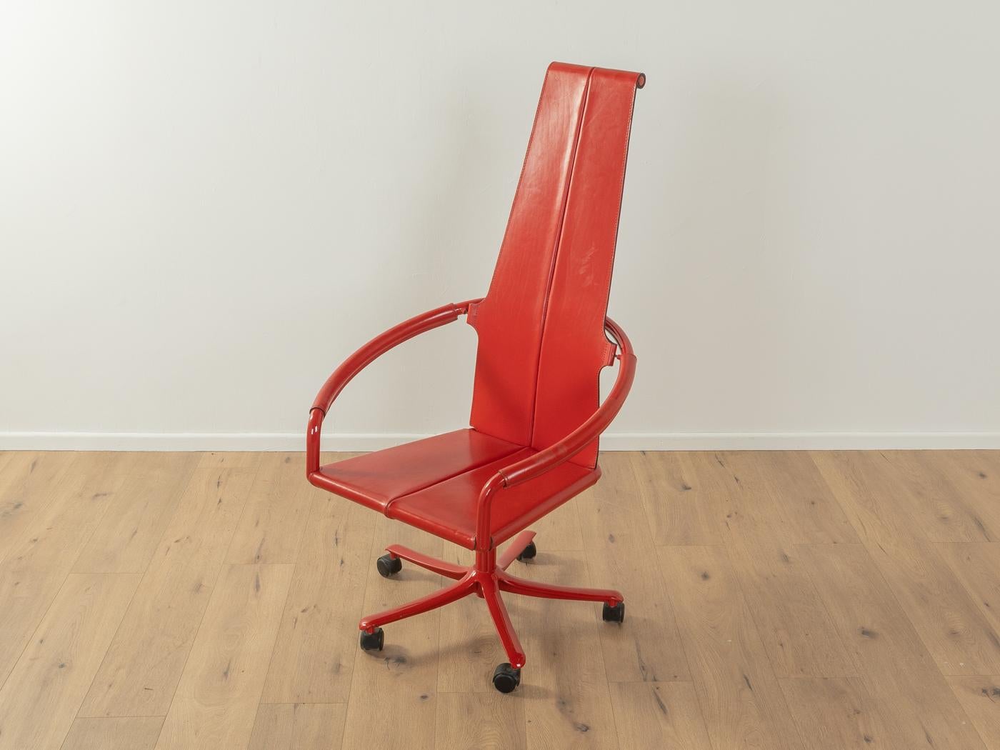 Rare fauteuil pivotant postmoderne de Cofemo datant des années 1980. Cadre en acier laqué rouge de haute qualité avec roulettes en plastique. Le siège et le dossier sont recouverts du cuir rouge d'origine. La chaise est rotative et réglable en