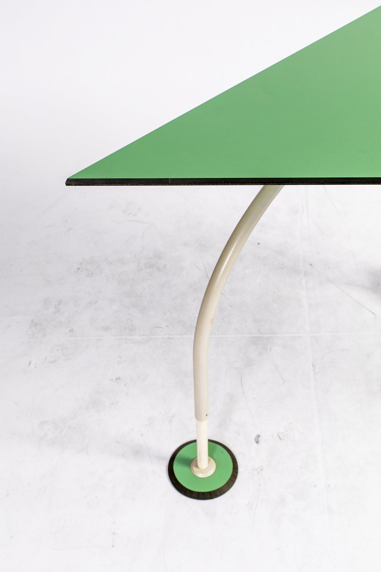 Vintage Italian side table, probably a creation of Memphis Milano precursors in the late 1970s, that can also be used as a chic desk. It features a metallic structure and green fiber glass top. The caster shaped leg is purely