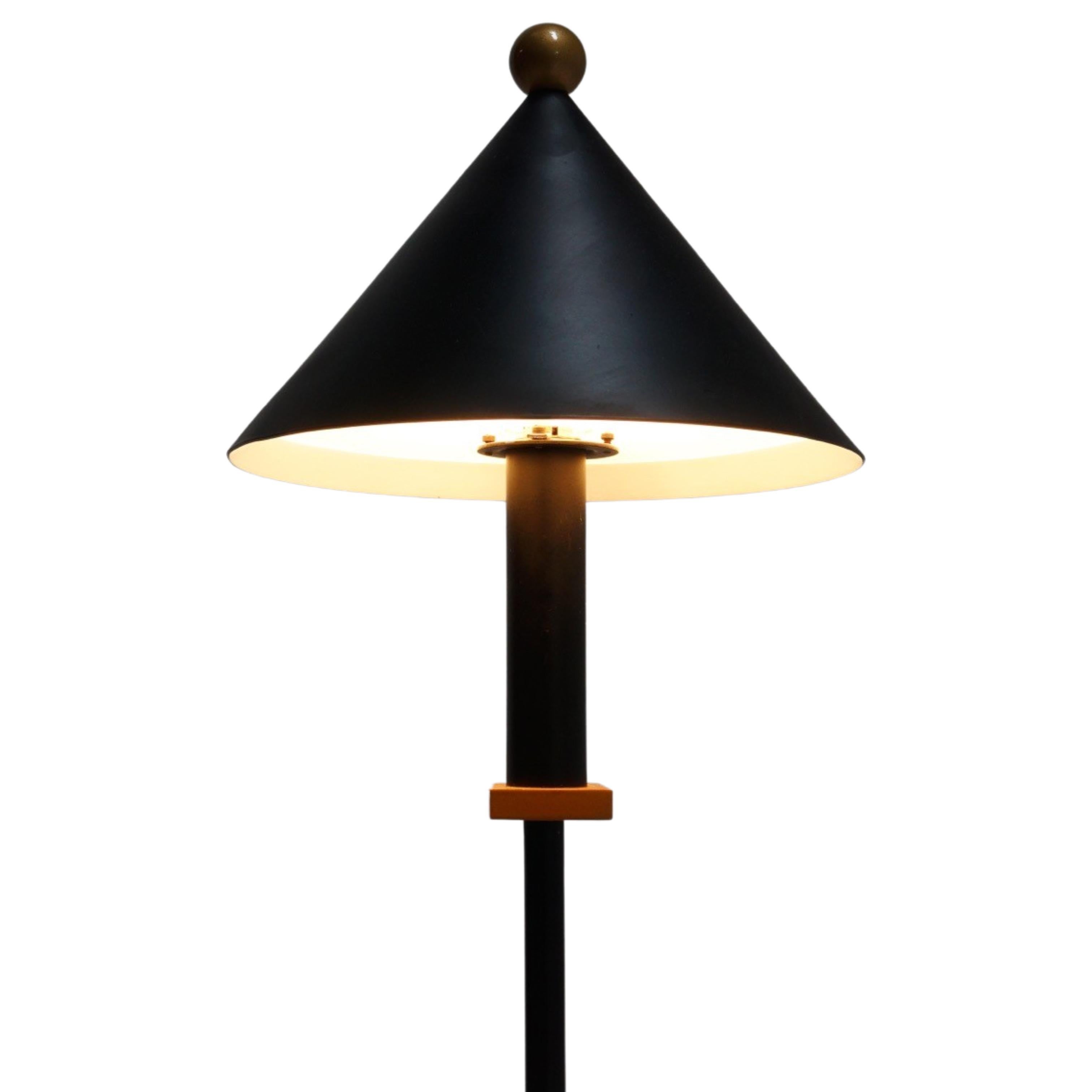 This 1990s postmodern black metal table lamp is living ode to the whimsical charm of the Memphis style. This Robert Sonneman designed piece is a quinessential tribute to the Memphis group'suse of unconventional and asymmetrical geometric shapes.