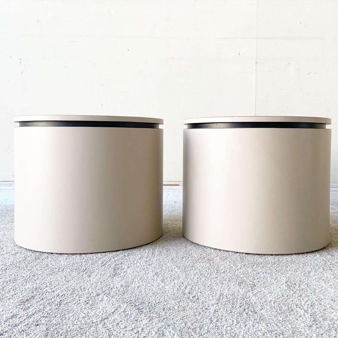 Amazing pair of vintage postmodern side tables on casters. Each feature a tan lacquer laminate with a black strip bordering the top.