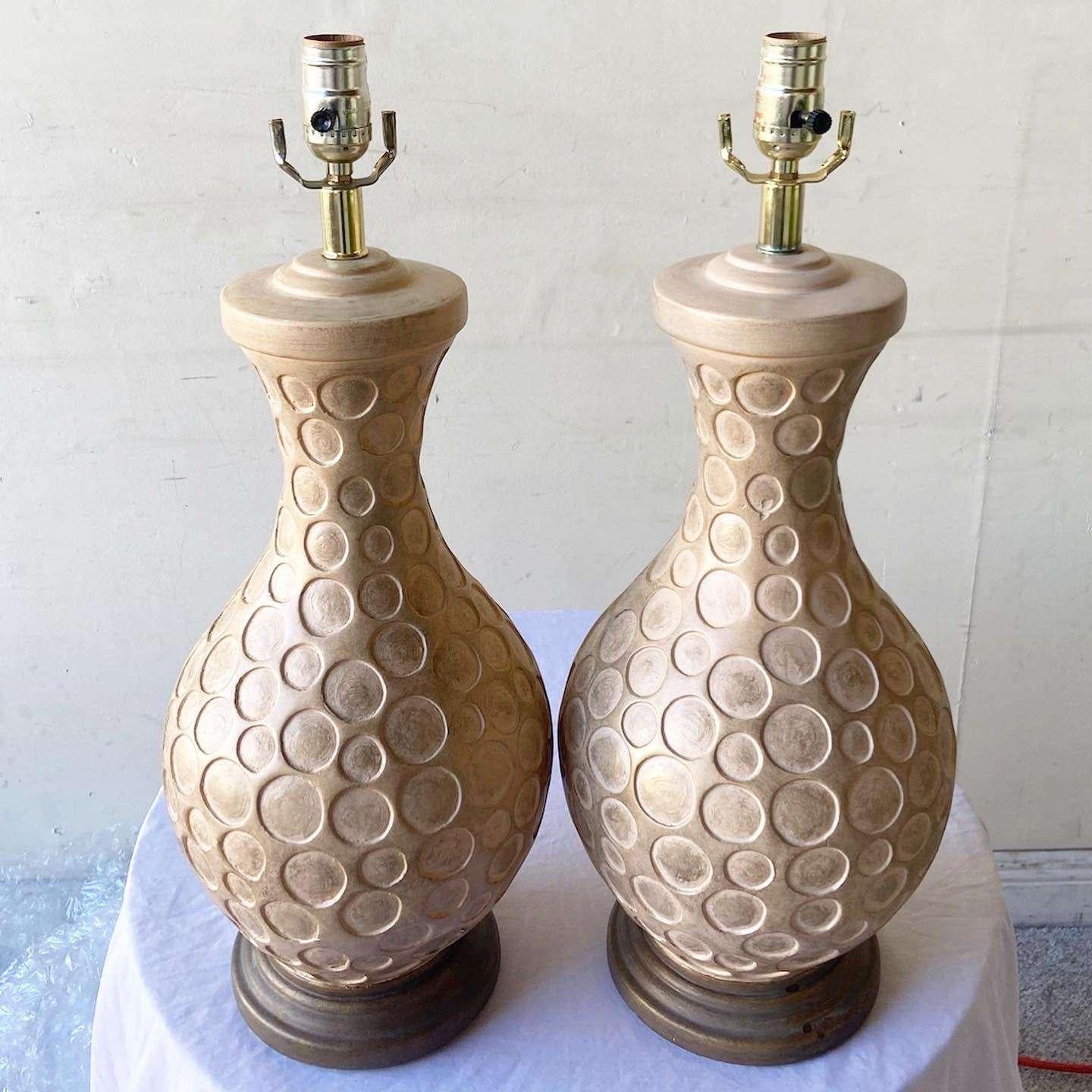 Amazing pair of postmodern table lamps. Each feature a tan body tessellated with circles.
