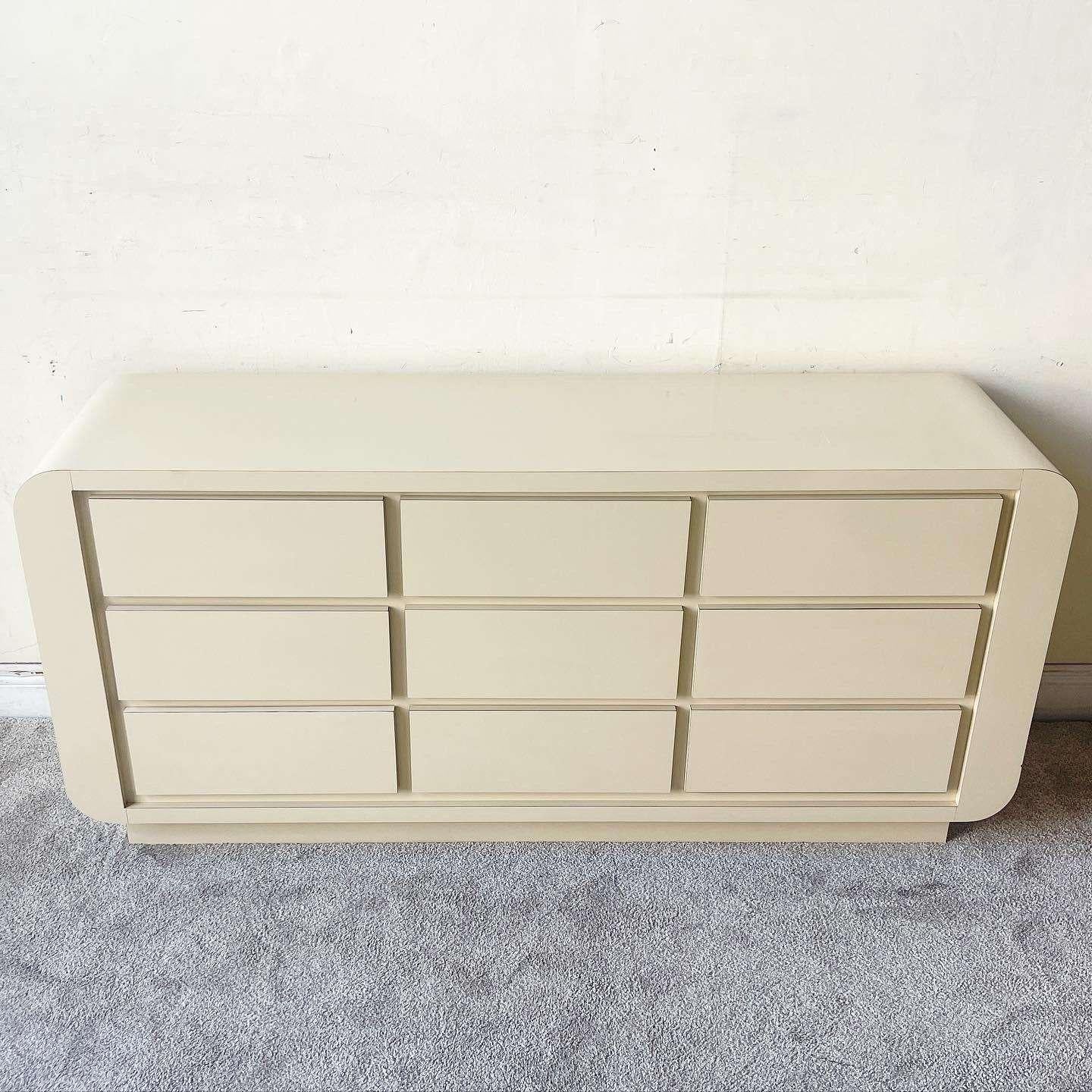 Amazing vintage 1980s postmodern waterfall dresser. Features a tan lacquer laminate with 9 spacious drawers.
  