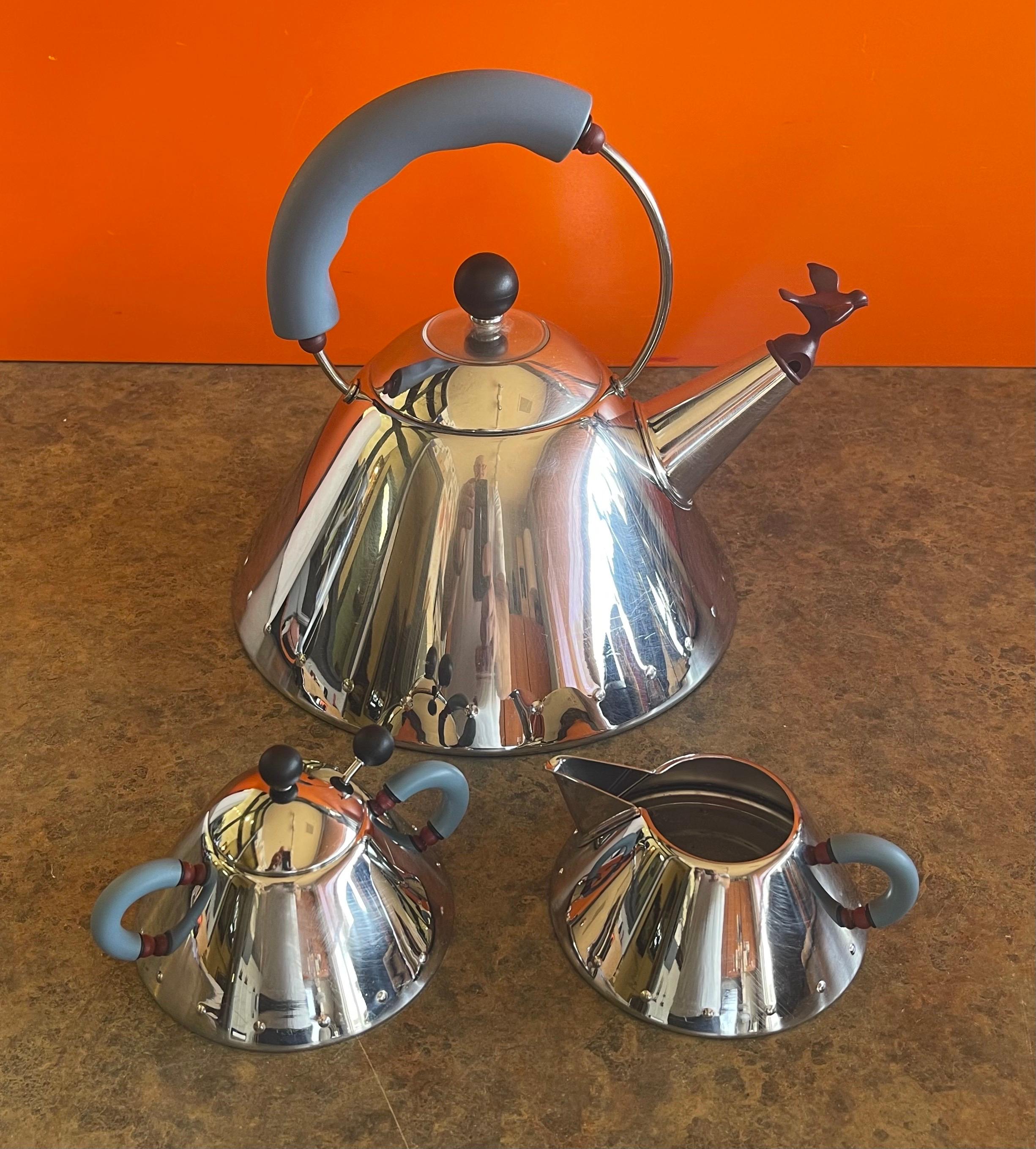 A classic postmodern / Memphis era teapot with cream & sugar designed by Michael Graves for Alessi, circa the 1980s. The set is in good vintage condition and measures 10.25