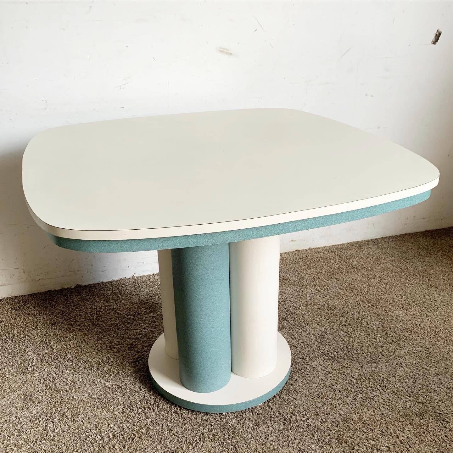 Plongez dans le monde amusant et vibrant du design postmoderne avec cette table de salle à manger en stratifié Teal and White. Dotée d'une base ludique avec des piliers en sarcelle et blanc soutenant un plateau de table épuré, cette pièce capture