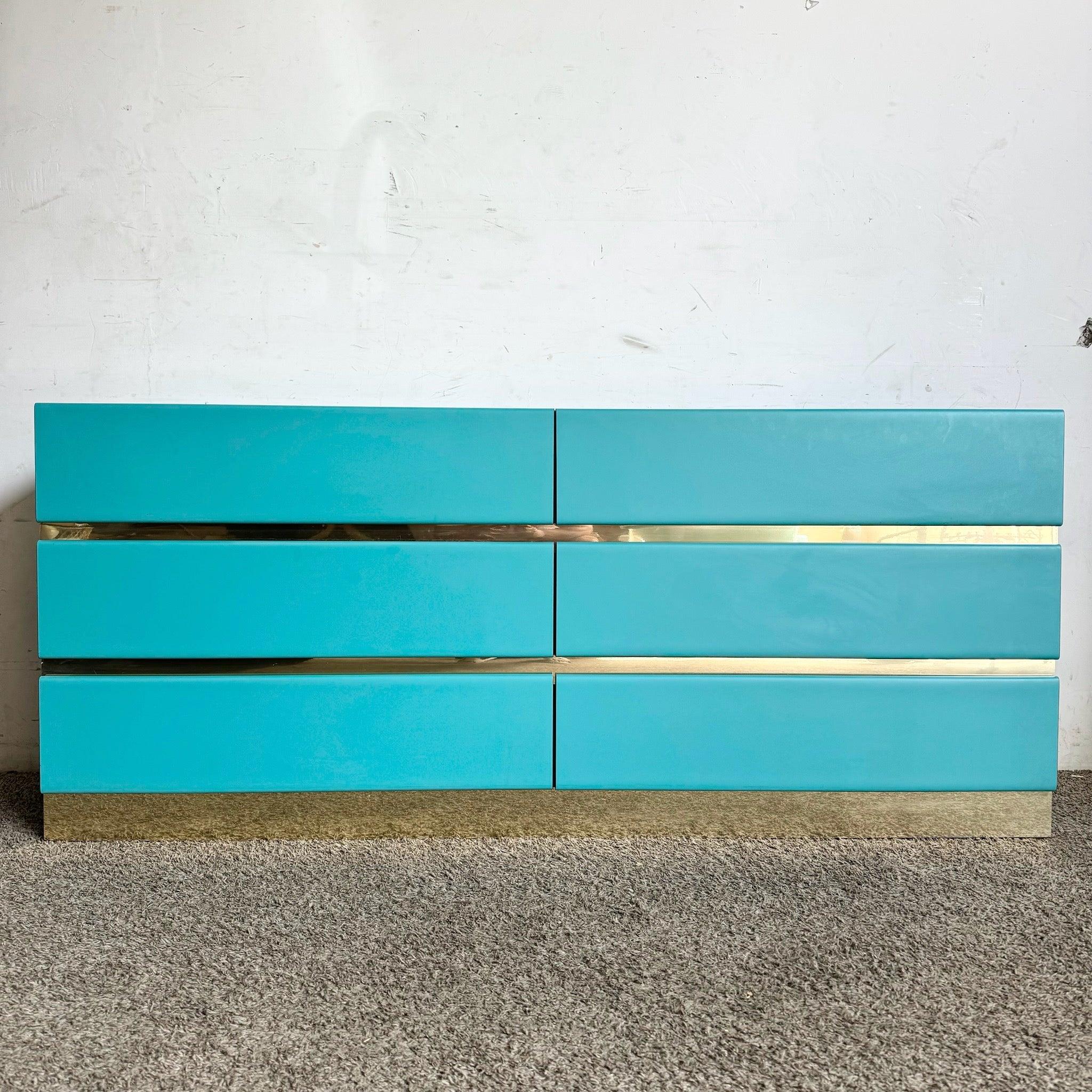 Die postmoderne Kommode aus tealfarbenem Laminat mit sechs Schubladen und goldenen Akzenten kombiniert kühnen Stil und Funktionalität und eignet sich perfekt für schicke, moderne Innenräume.
 
 Ein kleiner Chip in der hinteren Ecke und einige