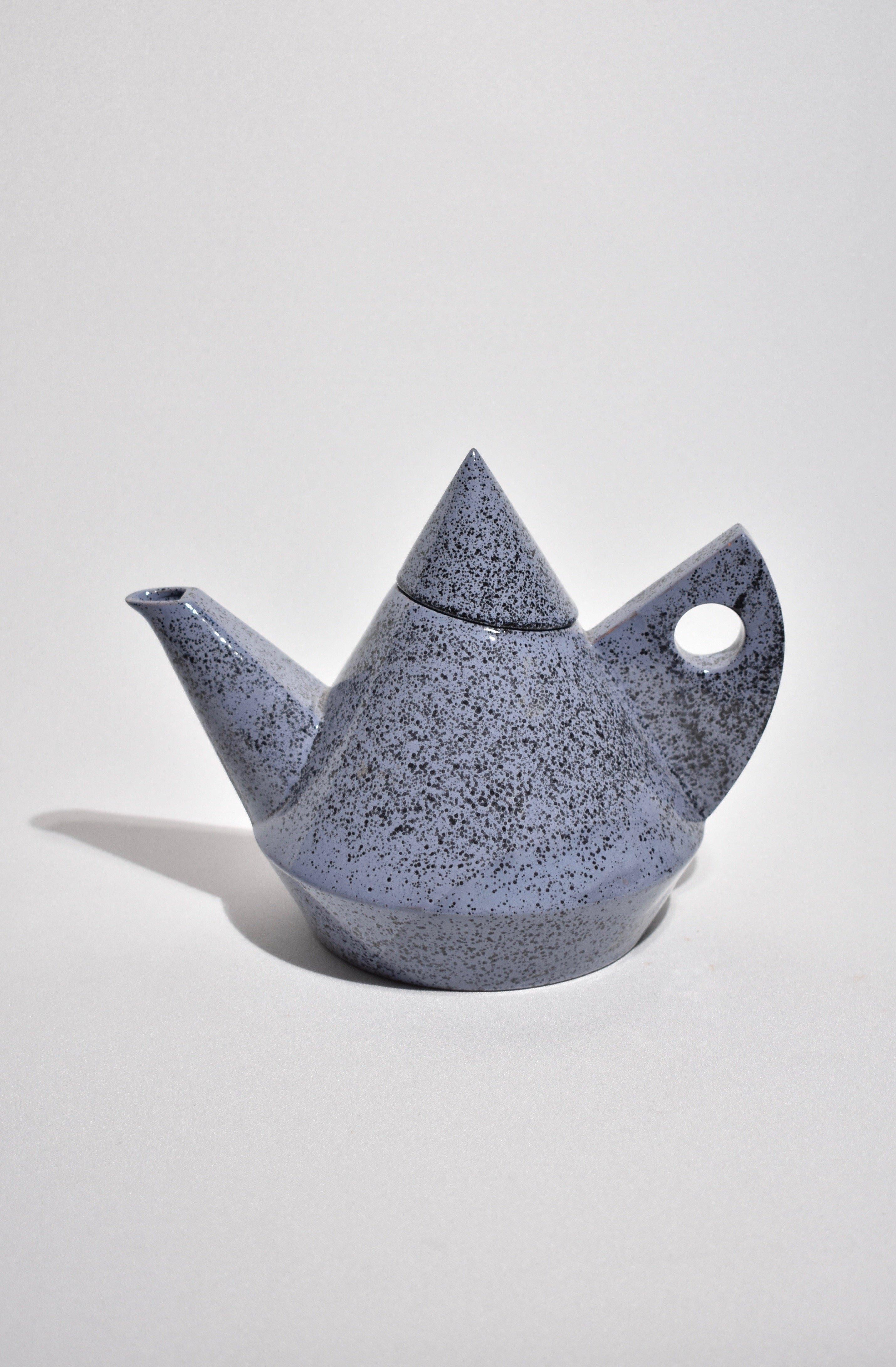 Rare, sculptural tea set in blue speckle pattern. Includes lightweight enamelware teapot and ceramic lidded sugar bowl, signed. 

Dimensions: 
Teapot measures 9.5” L, 6” W, 7” H. 
Sugar bowl measures 5” W, 4.25” H.