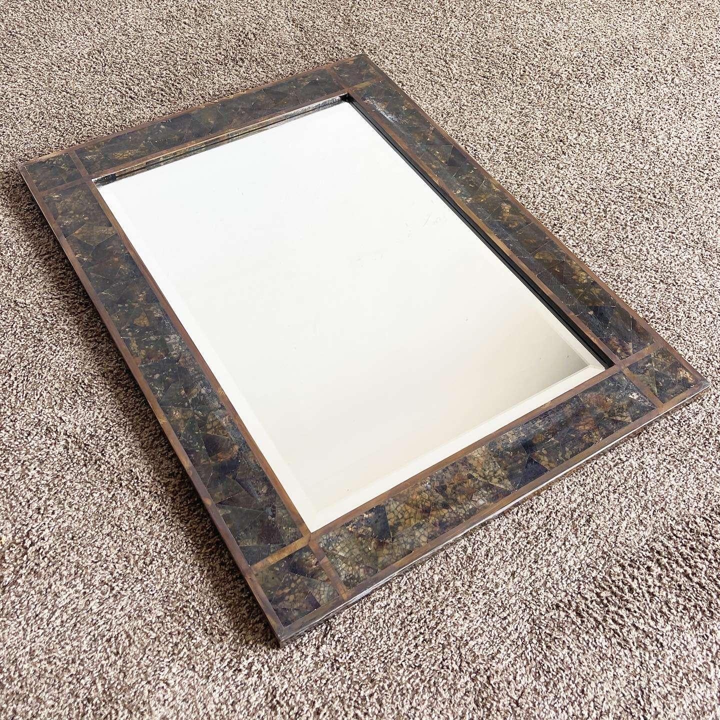 Wonderful vintage postmodern wall mirror designed by Maitland Smith. Features a tessellated stone frame with brass inlay.
