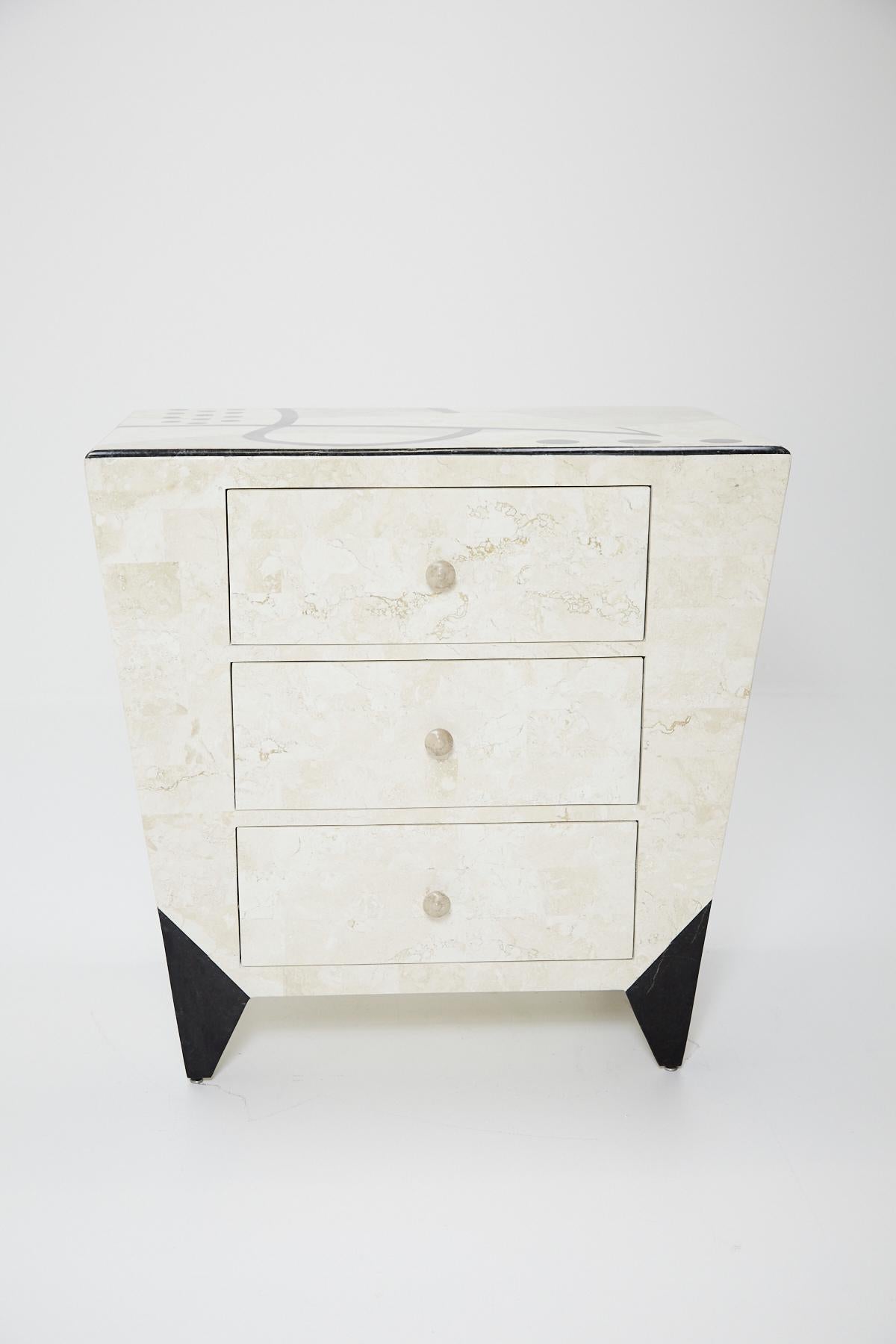 Fully covered tessellated stone square side table, small chest or nightstand with abstract Post Modern pattern across top in shades of white ivory, beige fossil and black inlaid stone. Stone inlaid over fiberglass body. Three front-facing