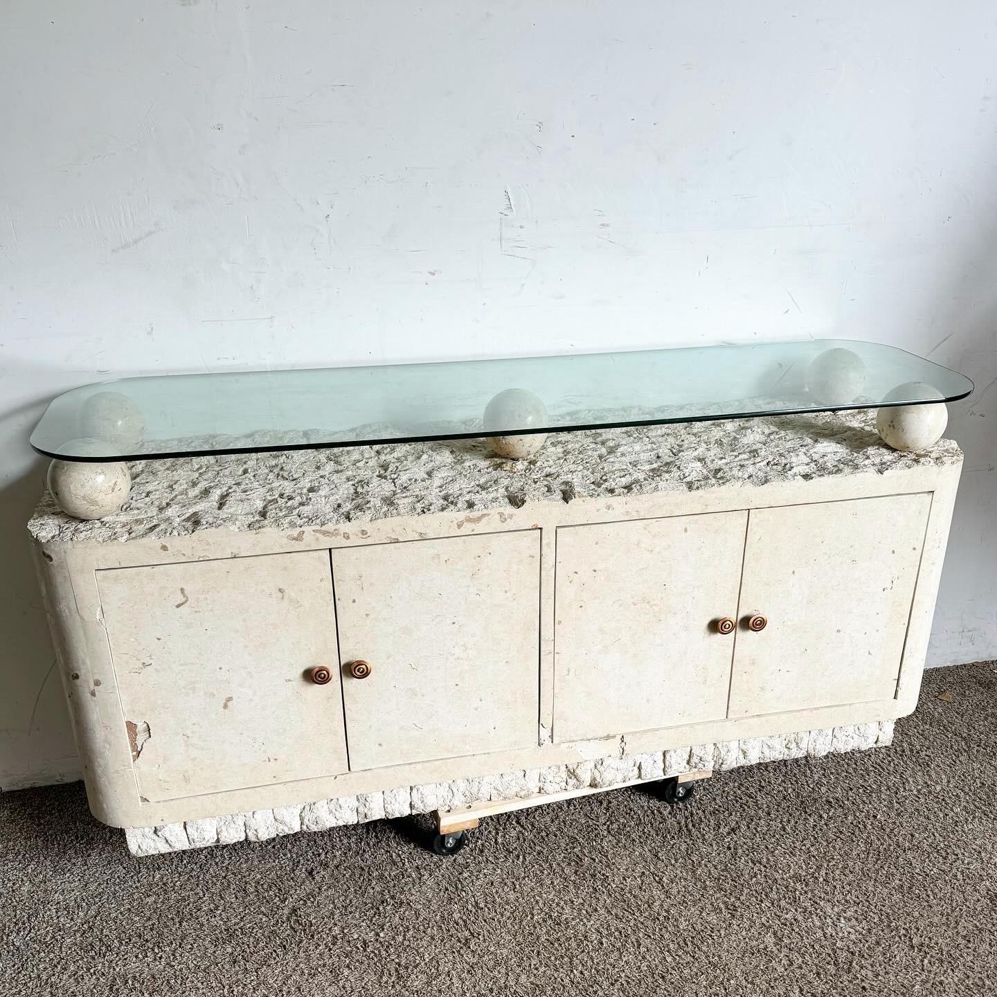 Elevate your interior with this stunning Postmodern Tessellated Stone Credenza, featuring a sleek glass top. Crafted in the 1990s, this piece showcases intricate tessellated stonework combined with the elegance of a smooth glass surface. Offering
