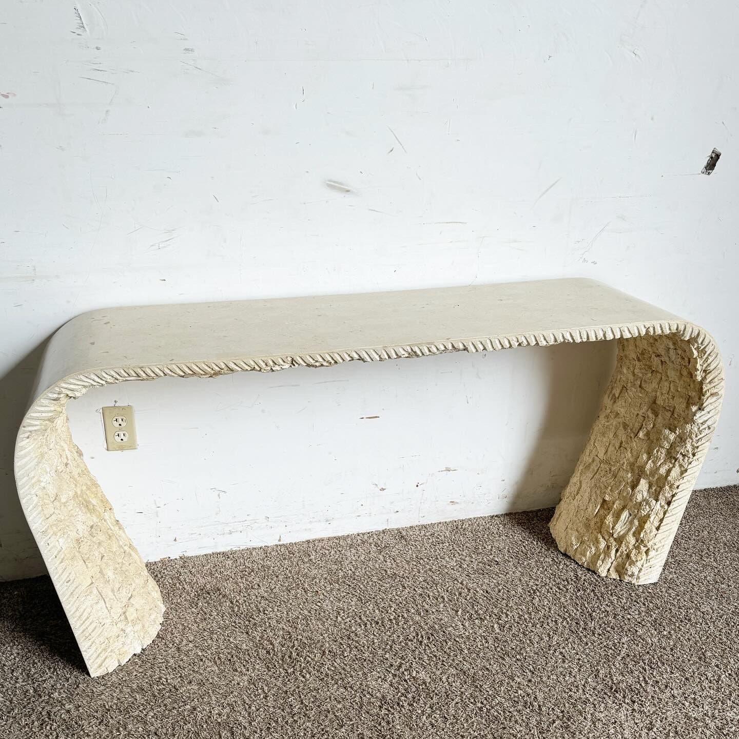 Adopta la elegancia única del diseño posmoderno con esta Mesa consola en cascada de piedra teselada, inspirada por Maitland Smith. Esta mesa presenta una superficie lisa pulida que contrasta espectacularmente con la parte inferior de piedra en